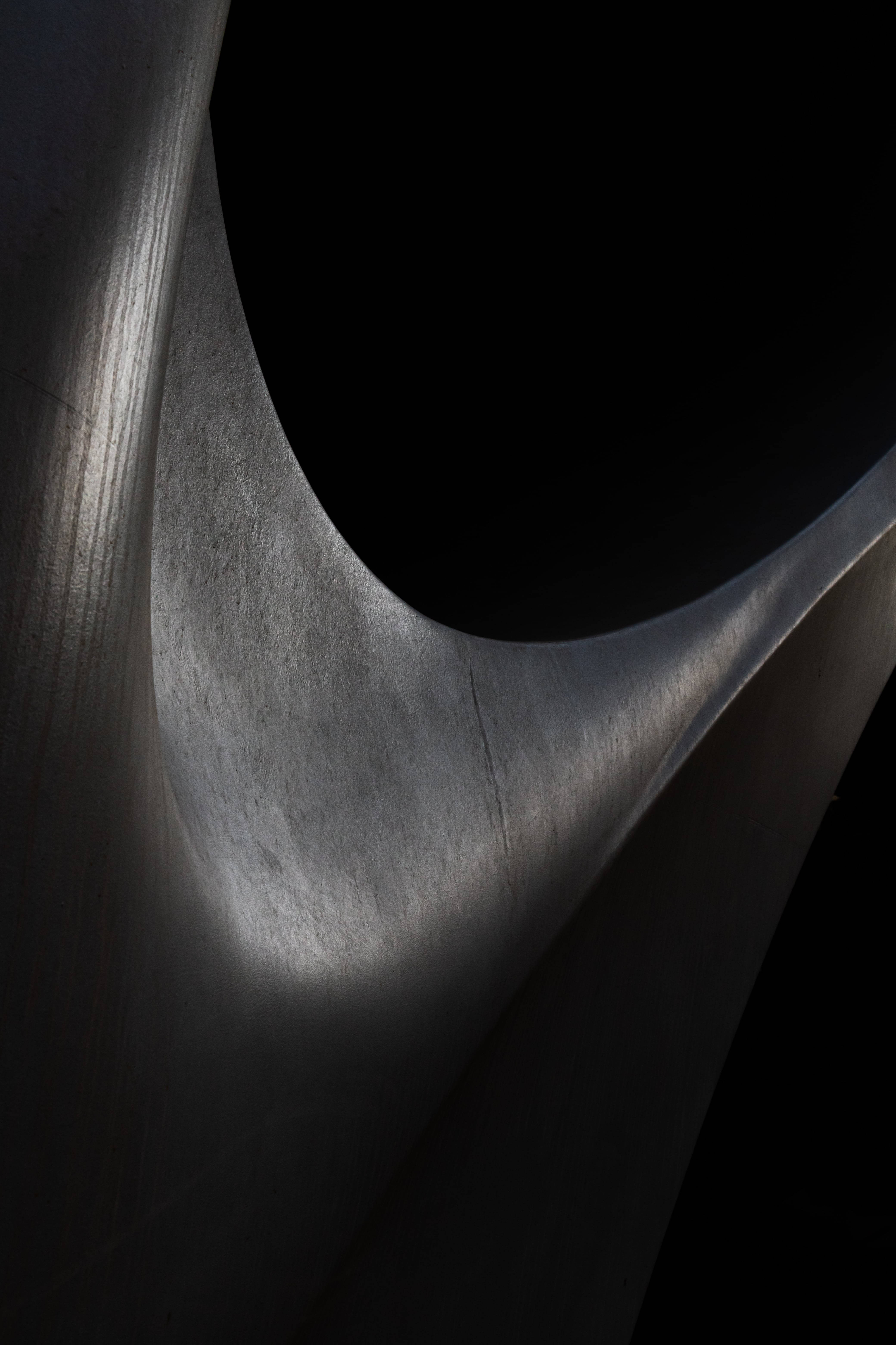 Abstrakt sort skulptur i et svagt oplyst rum Wallpapers