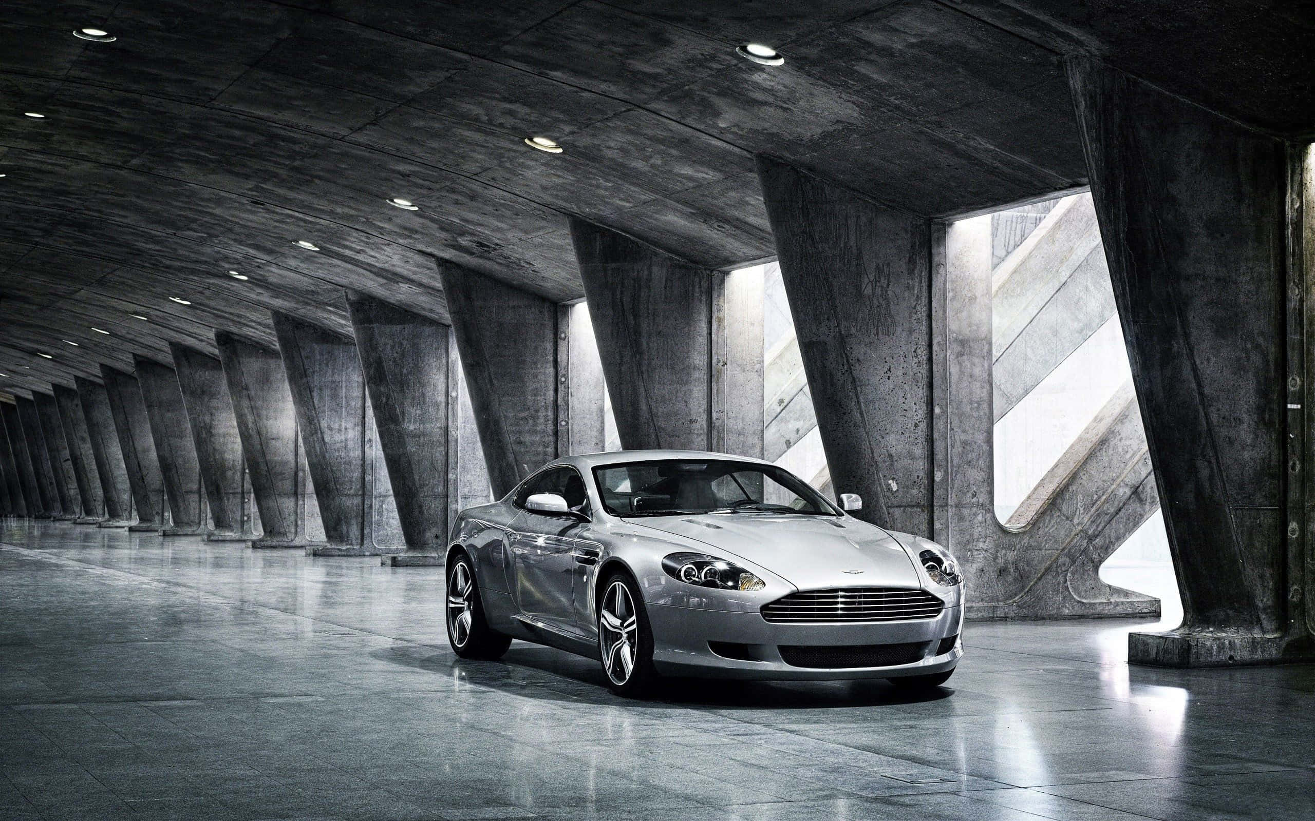 Aston Martin DB9 kører gennem en naturskøn byudsigt Wallpapers