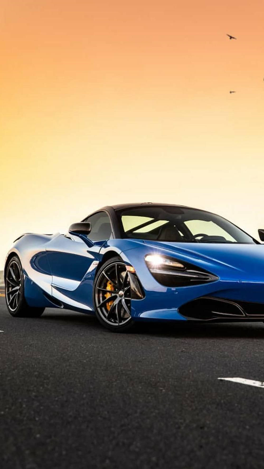 Blå McLaren 720S ved solnedgang til mobil Wallpapers