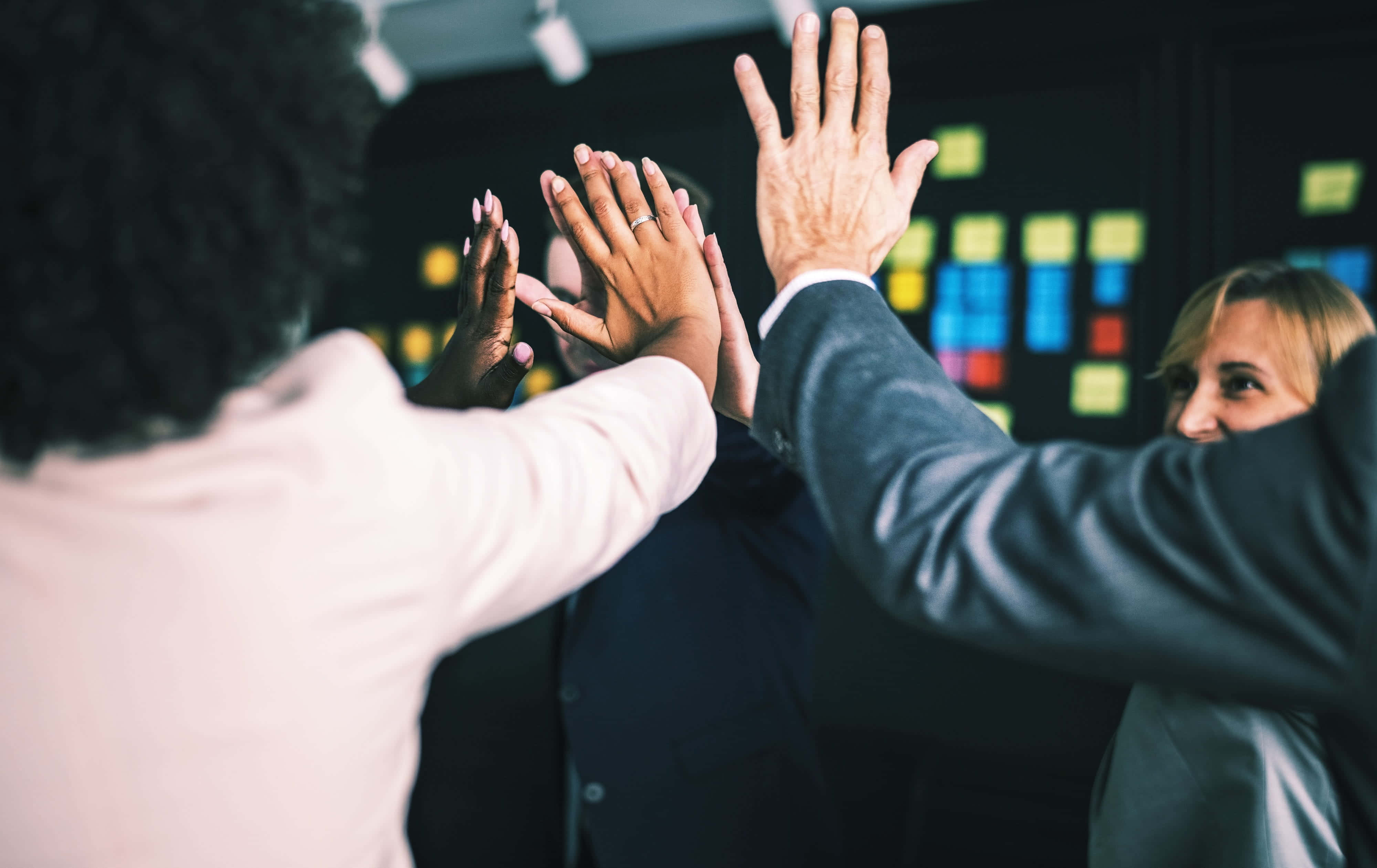 business people giving high fives in an office Wallpapers