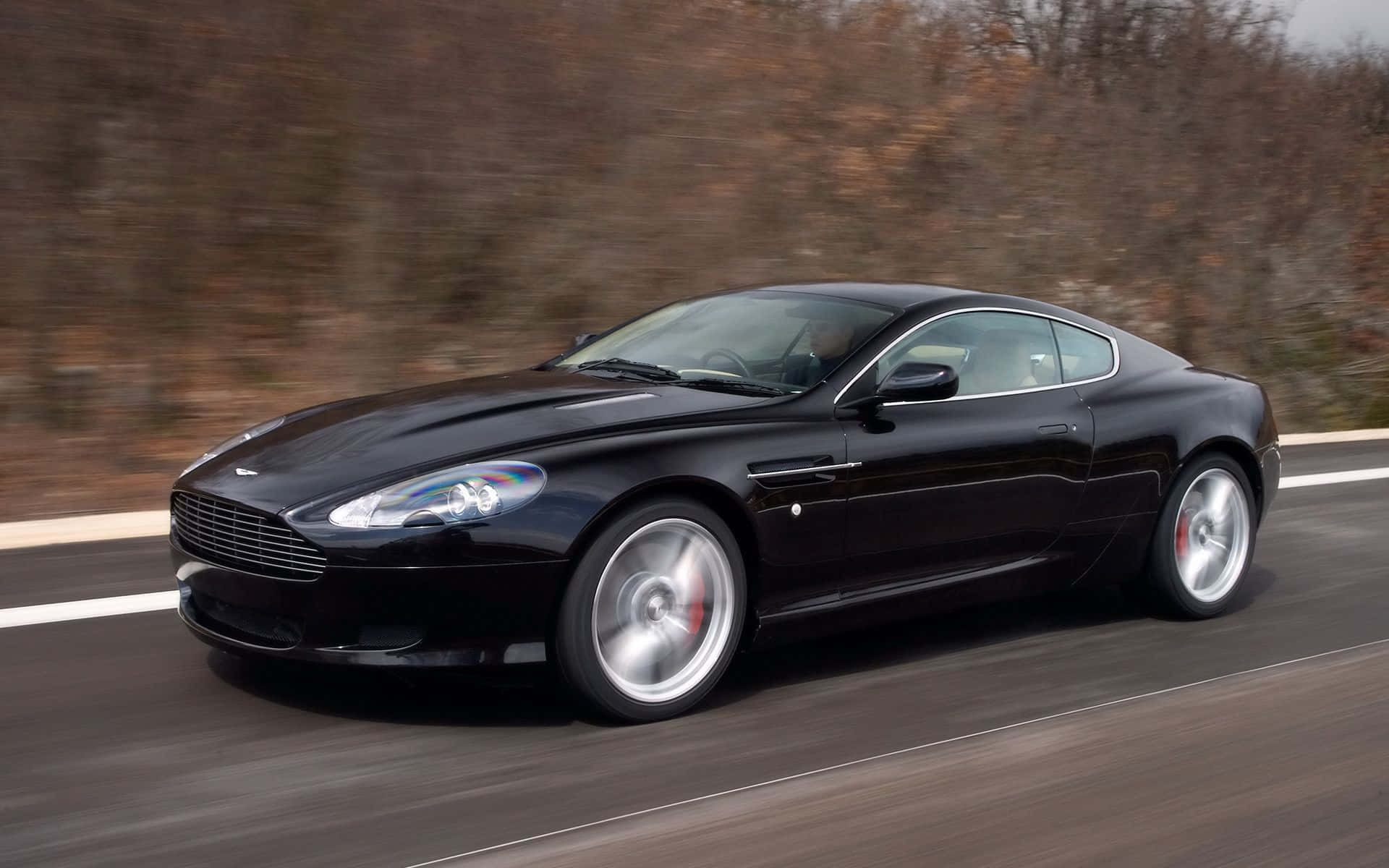 Elegant Aston Martin DB9 på en åben vej Wallpapers