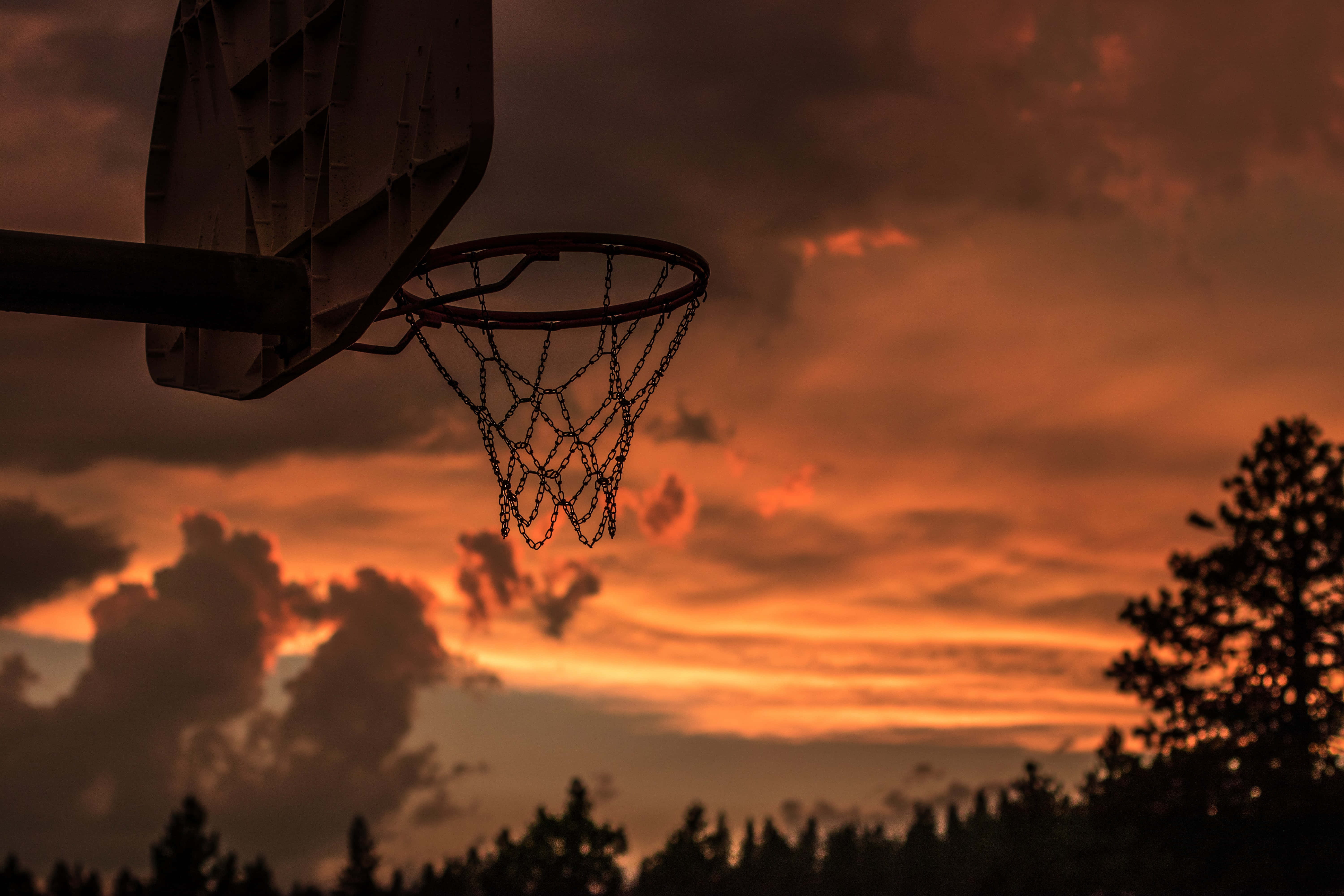 En basketballkurv med en solnedgangshimmel bagved Wallpapers