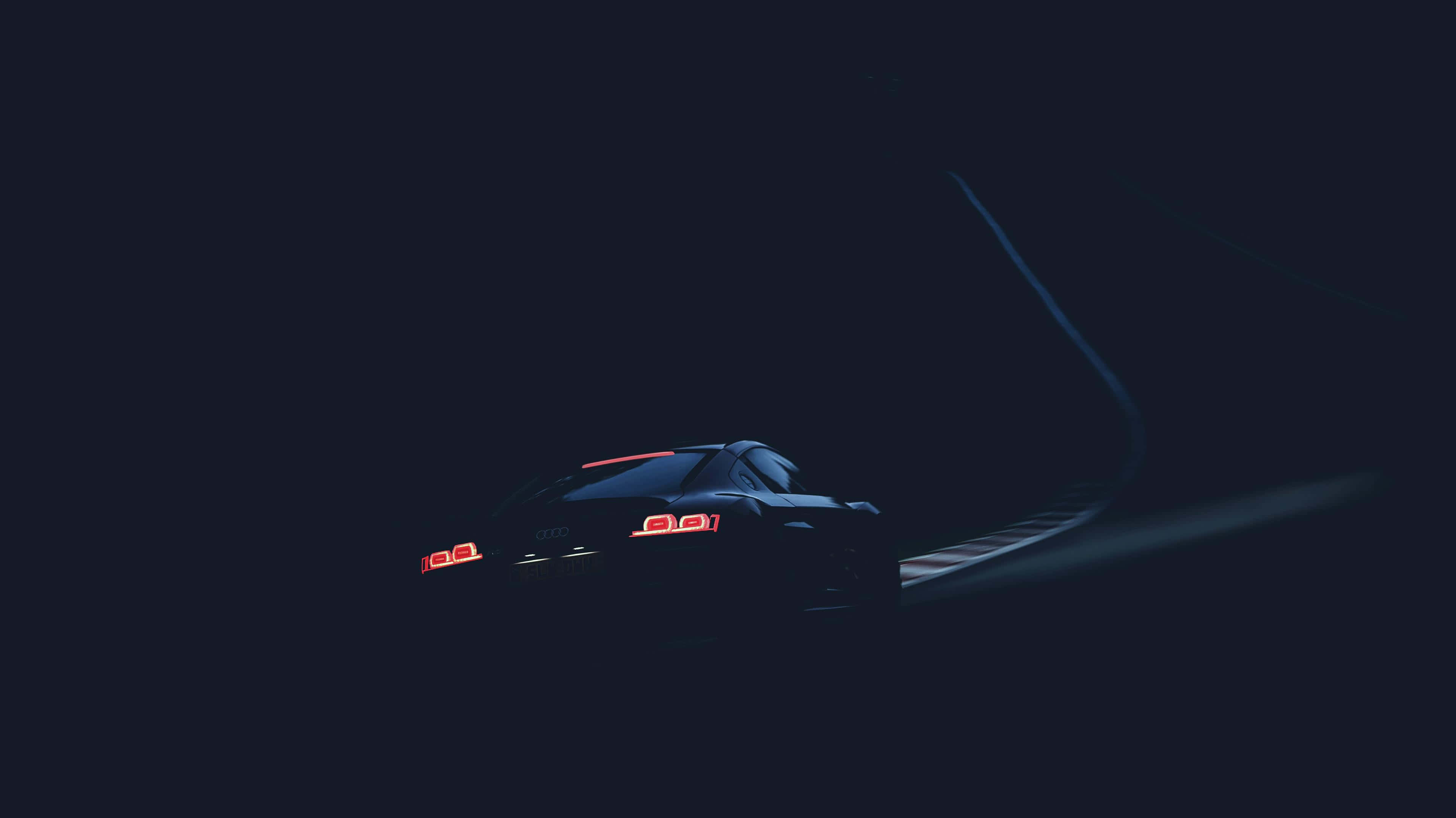 en bil kører ned ad en mørk vej Wallpapers