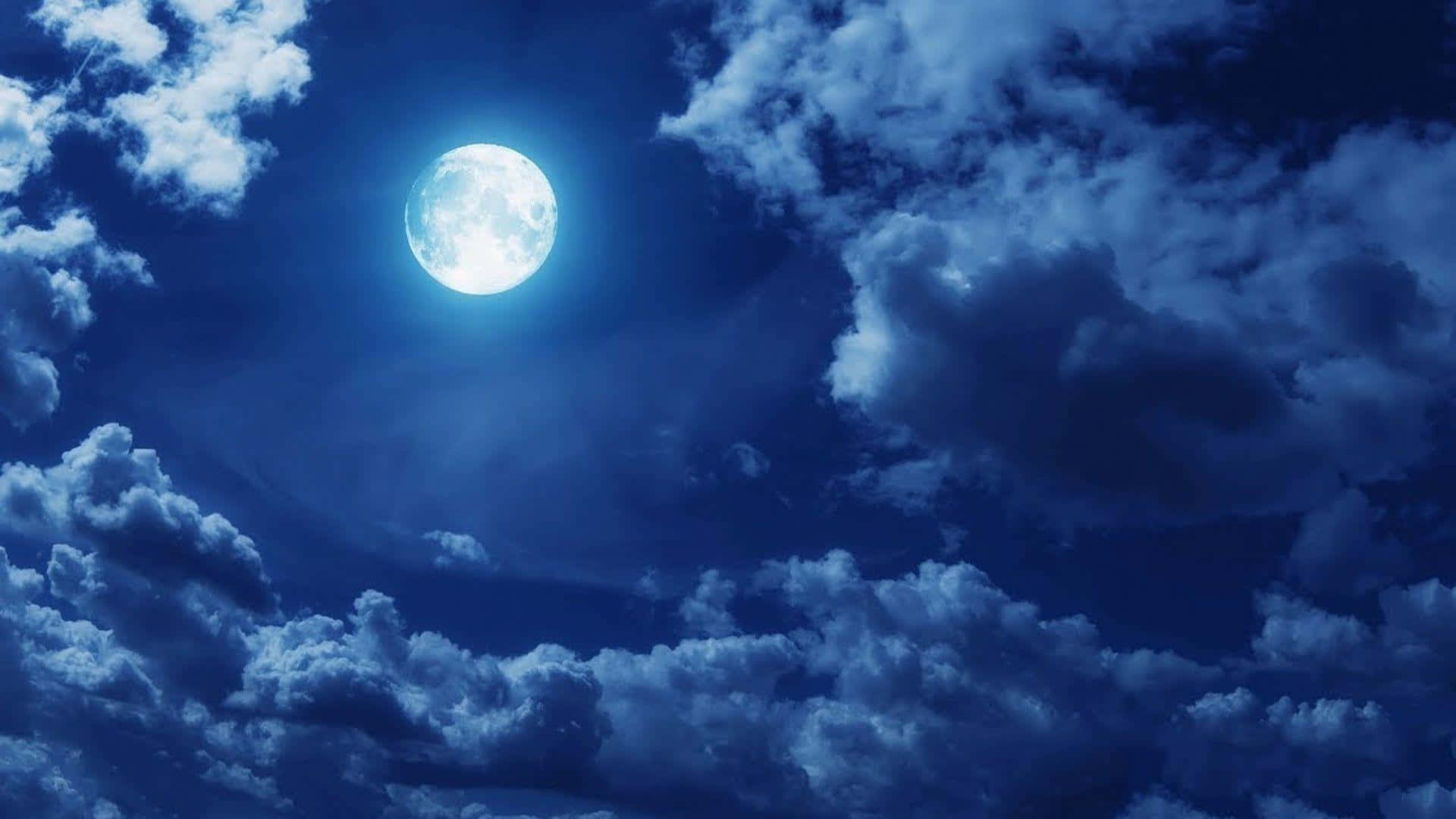 en fuldmåne ses gennem skyer på himlen Wallpapers