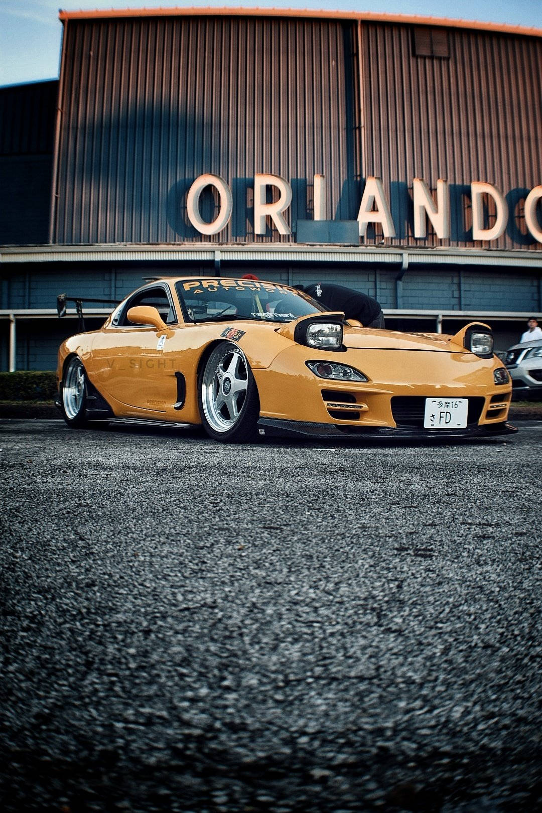 En gul sportsvogn parkeret foran en bygning Wallpapers