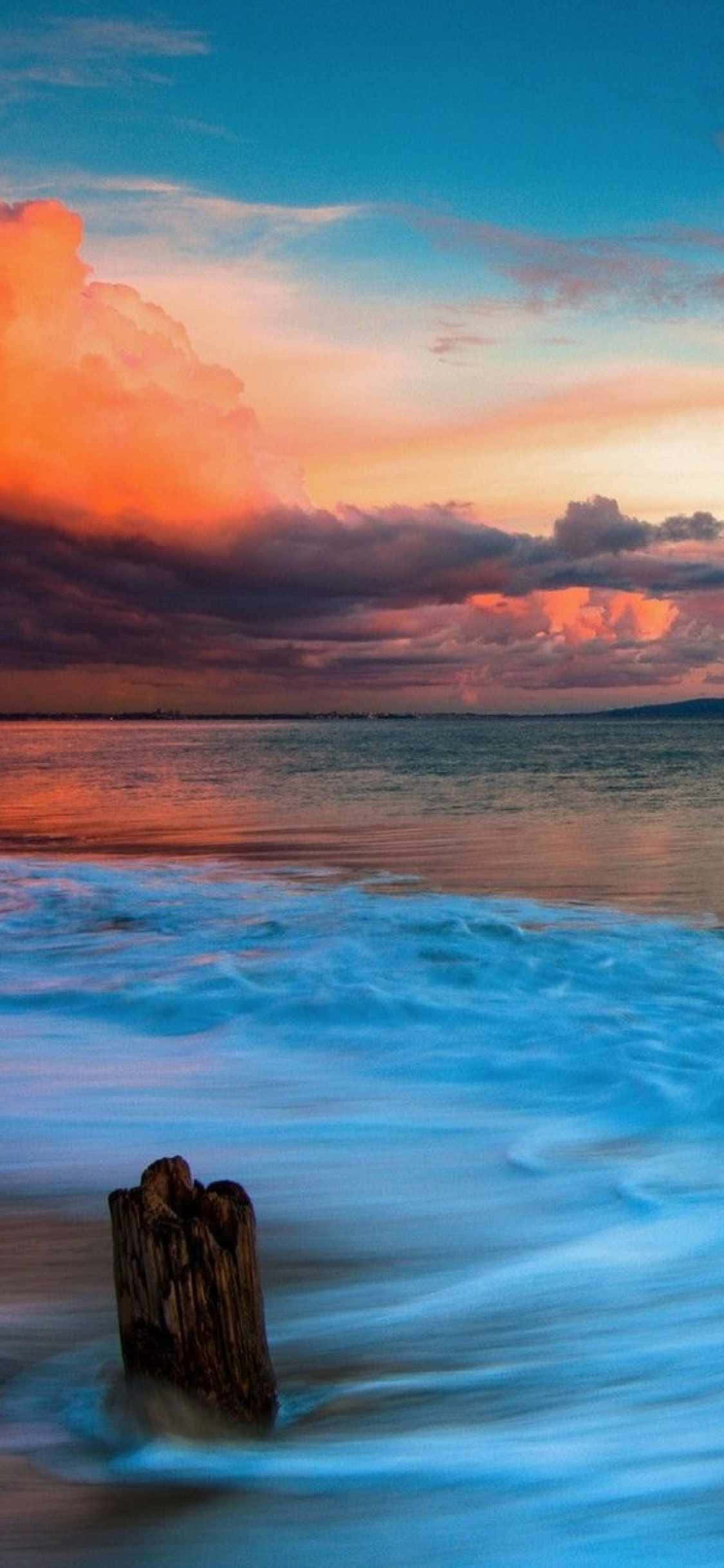 En idyllisk solnedgang over Malibu, Californien set gennem linsen på en iPhone Xs Wallpapers