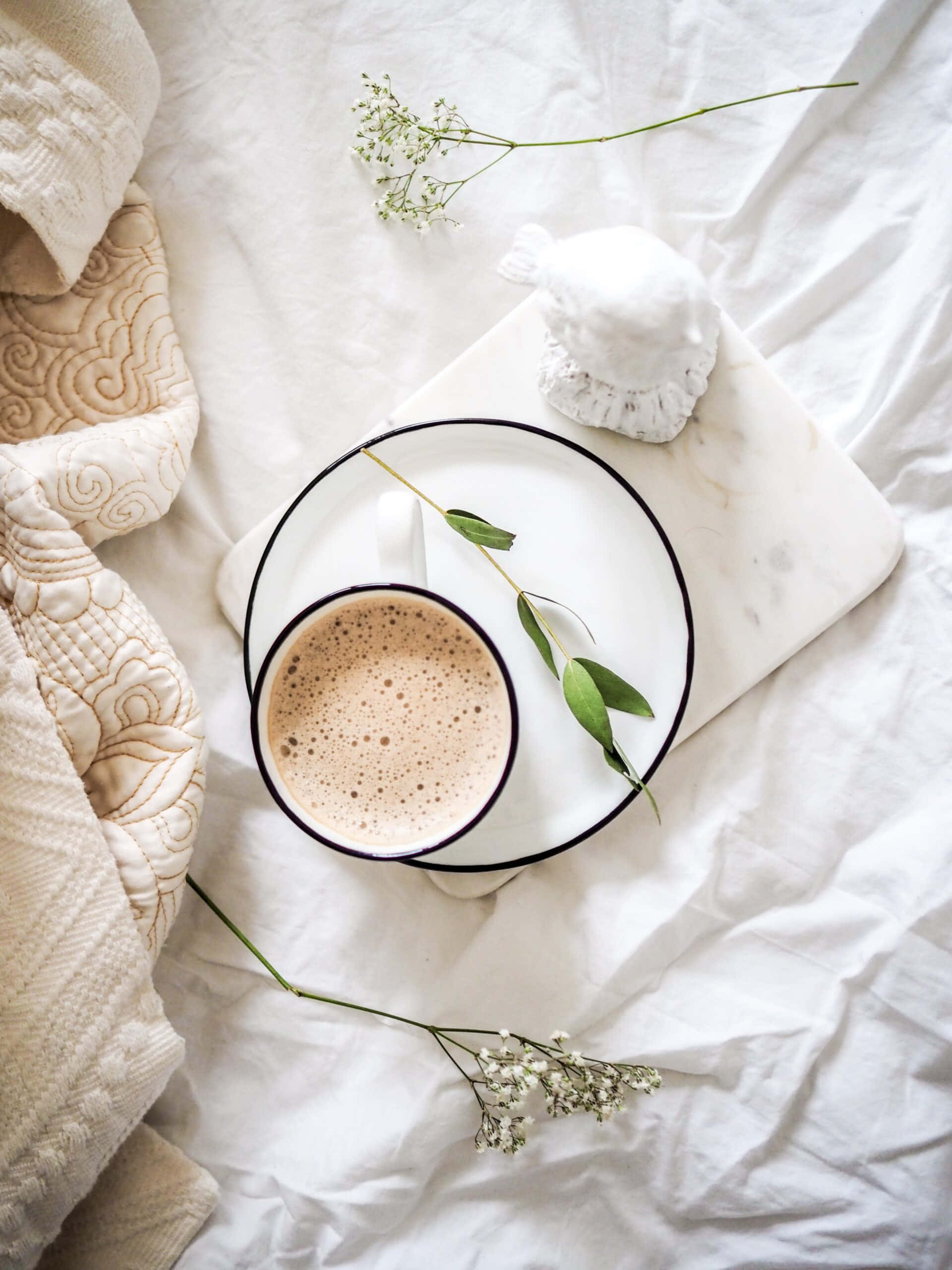 en kop kaffe på en seng med blomster Wallpapers