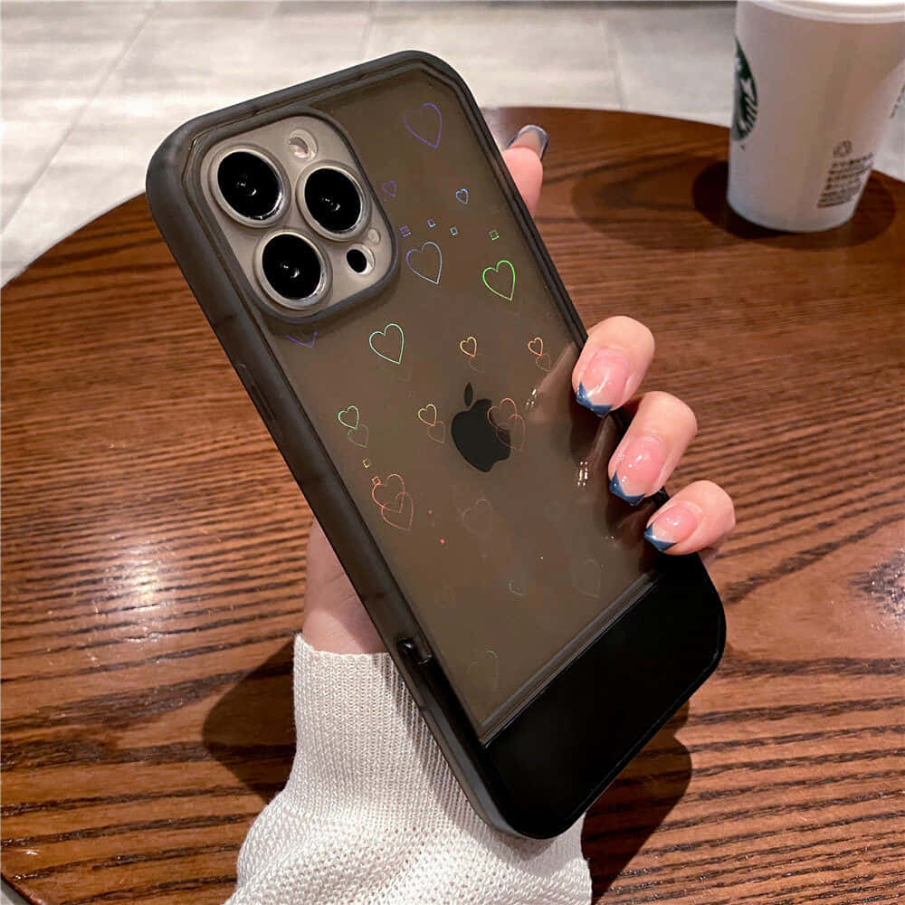 en kvinde der holder et iPhone 11 cover med hjerter på Wallpapers
