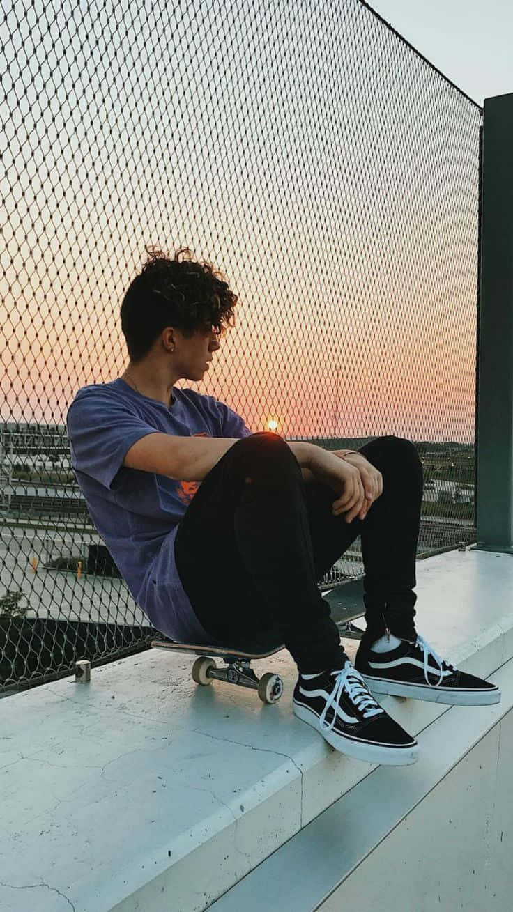 en mand der sidder på et skateboard Wallpapers