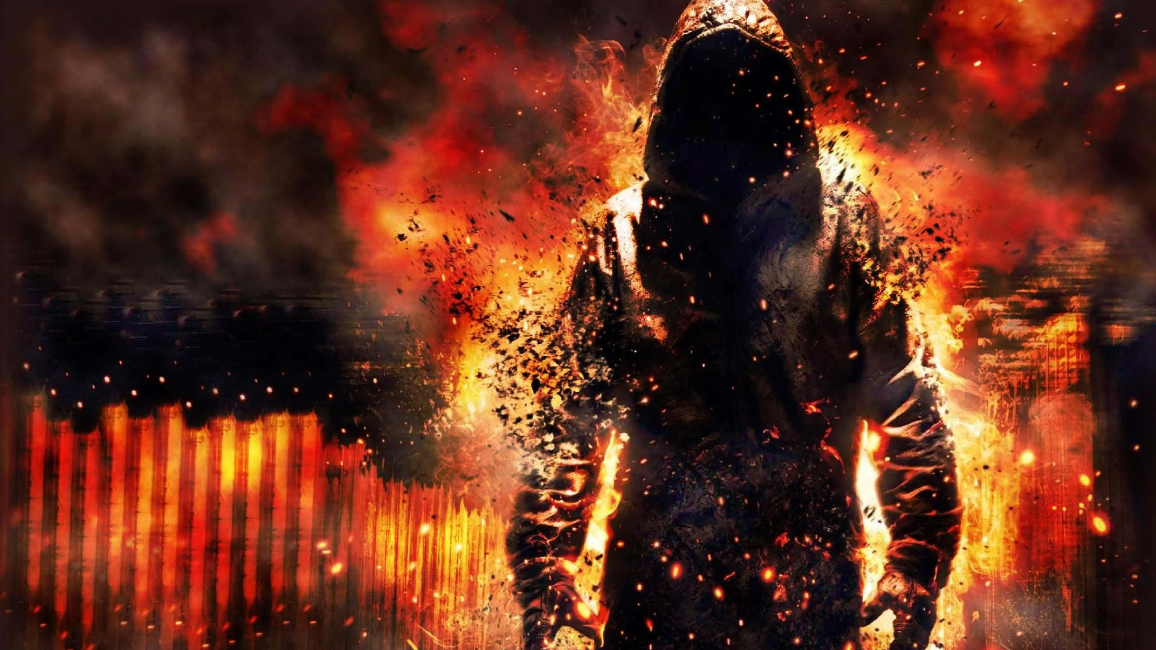 en mand i hættetrøje foran en brand Wallpapers