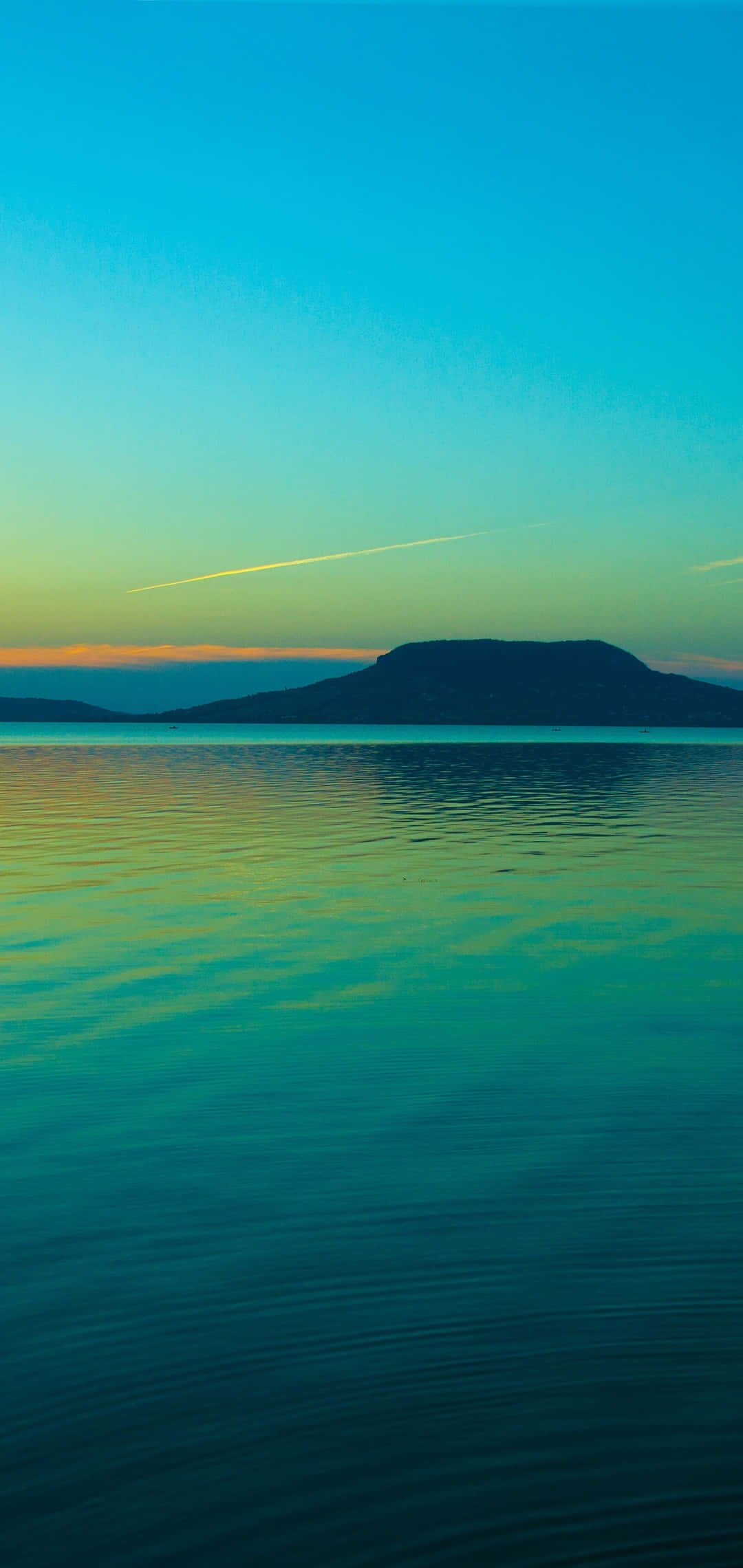 en mand sejler i en båd på en sø ved solnedgang Wallpapers