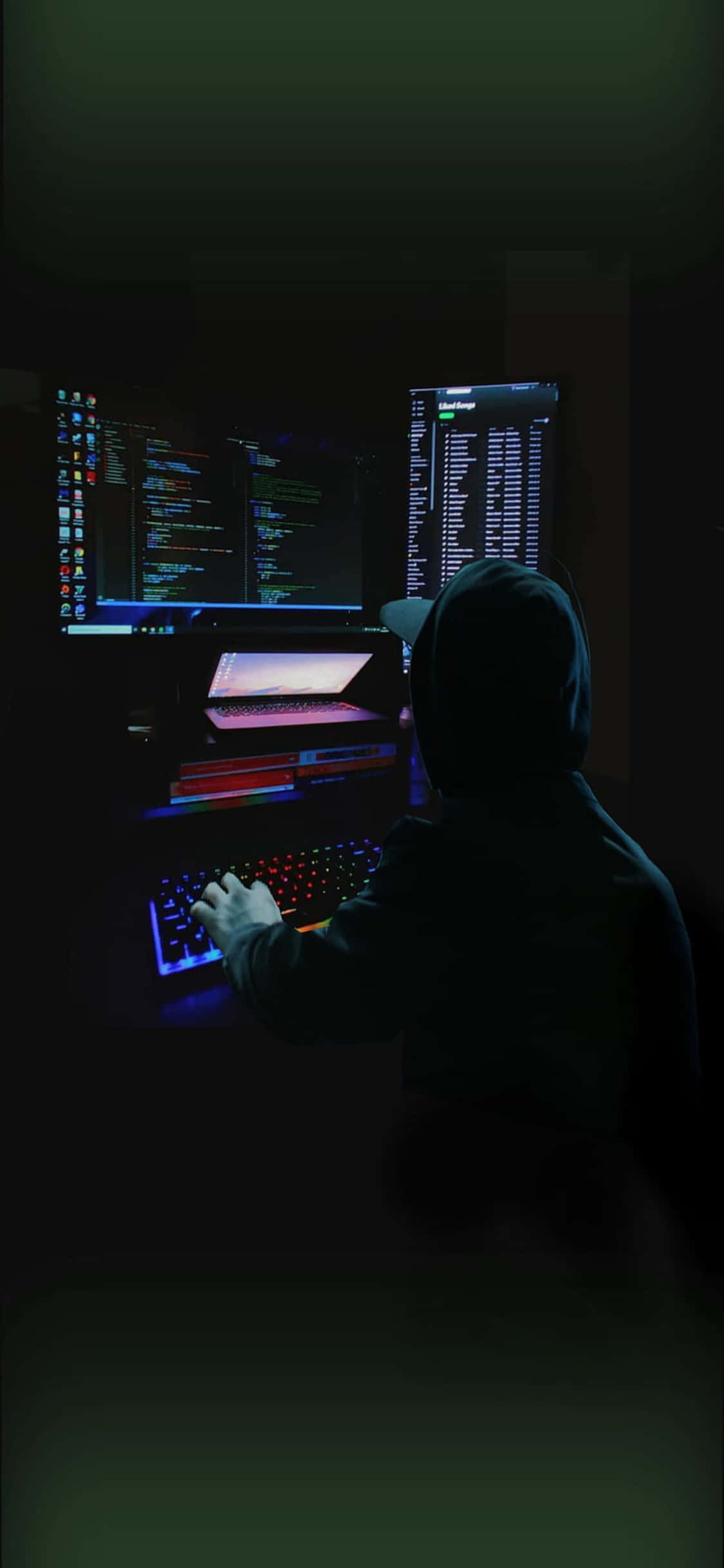 en mand sidder ved en computer i mørket Wallpapers