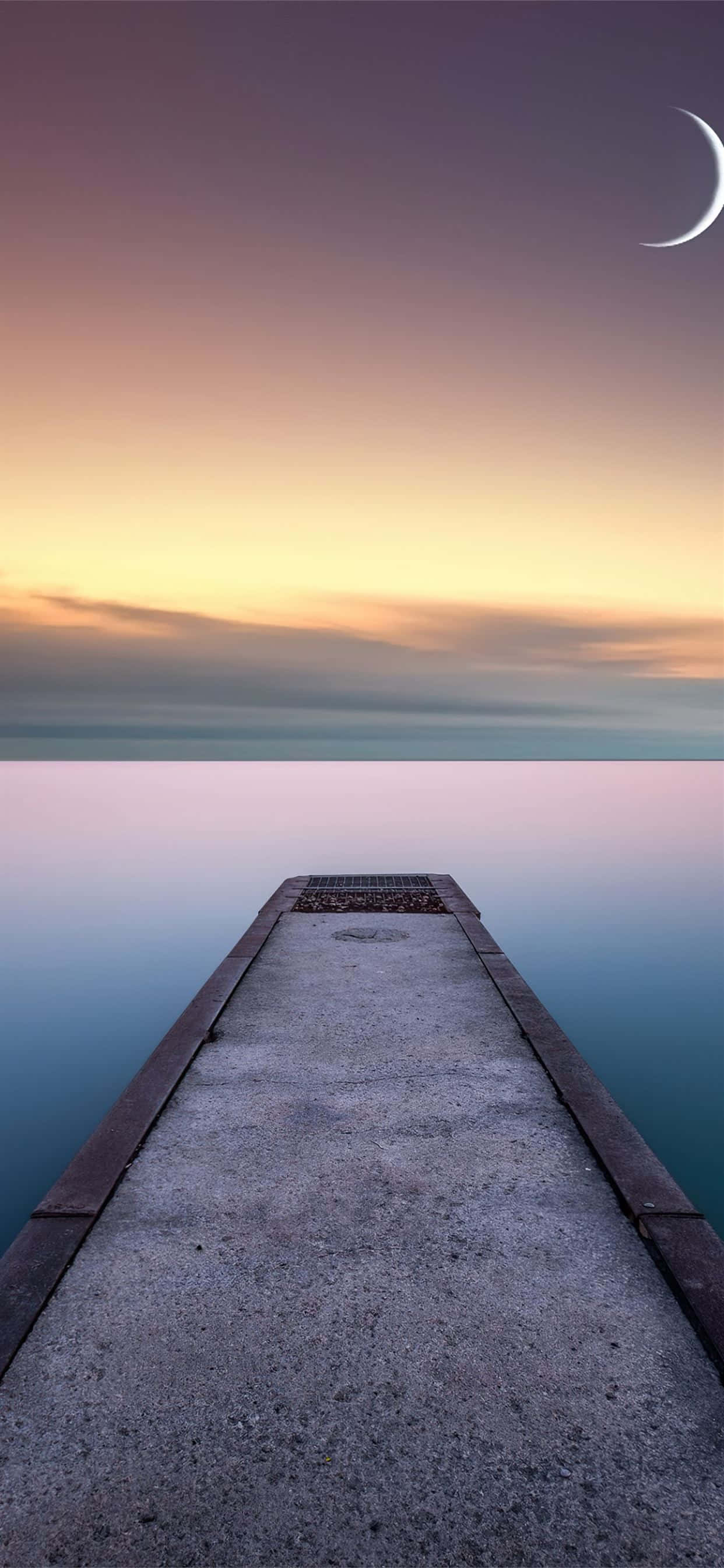 en mole, der fører ud til vandet med en halvmåne Wallpapers