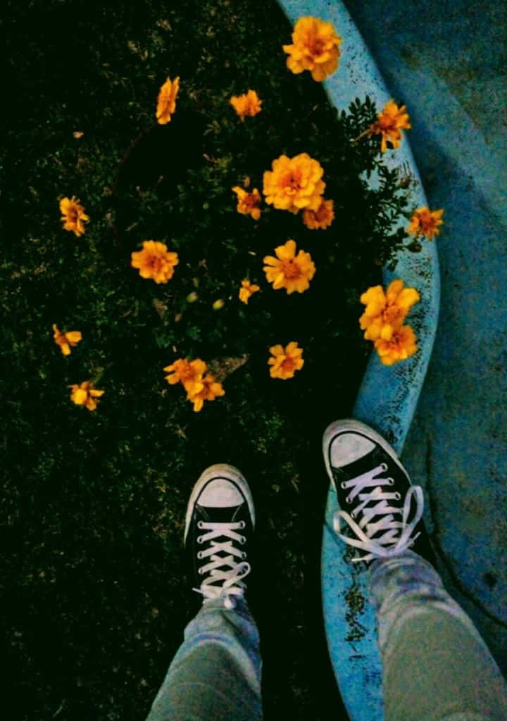 en person stående på et fortov med blomster Wallpapers