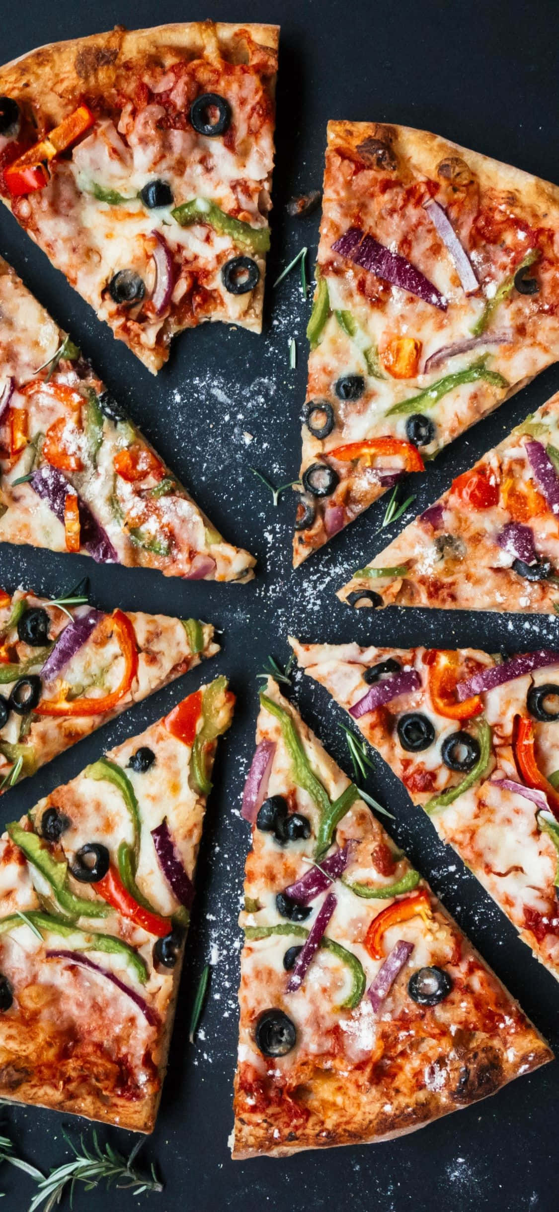 en pizza med grøntsager og oliven er skåret i stykker Wallpapers