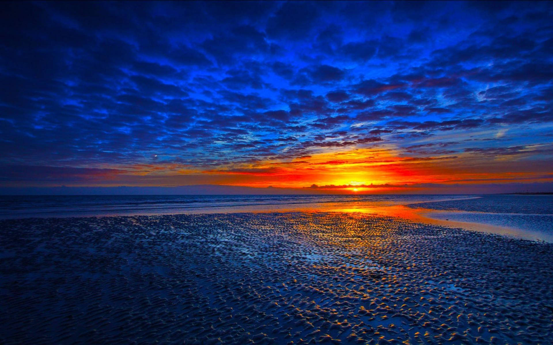 En pragtfuld solnedgang set fra en tropisk strand Wallpapers