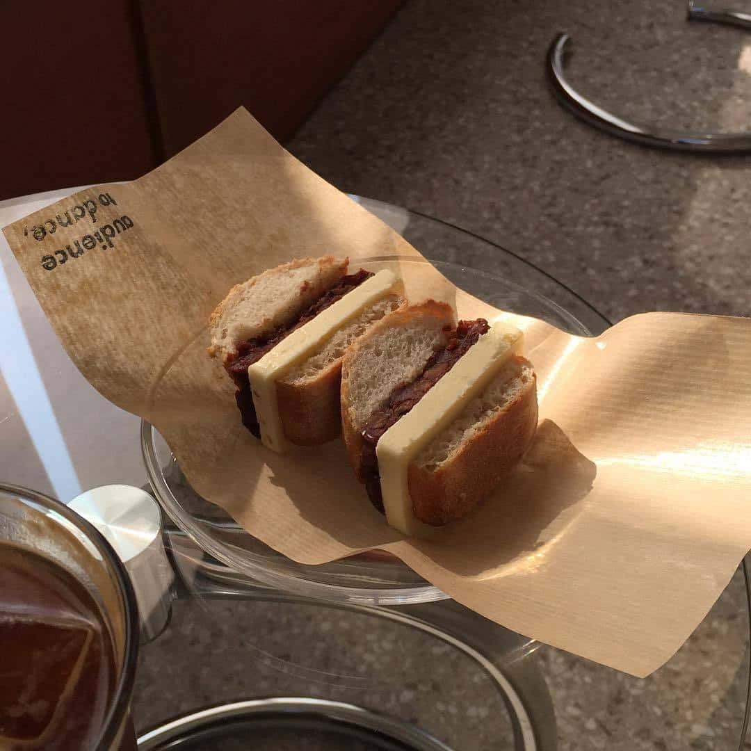 en sandwich på en tallerken med en kop kaffe Wallpapers