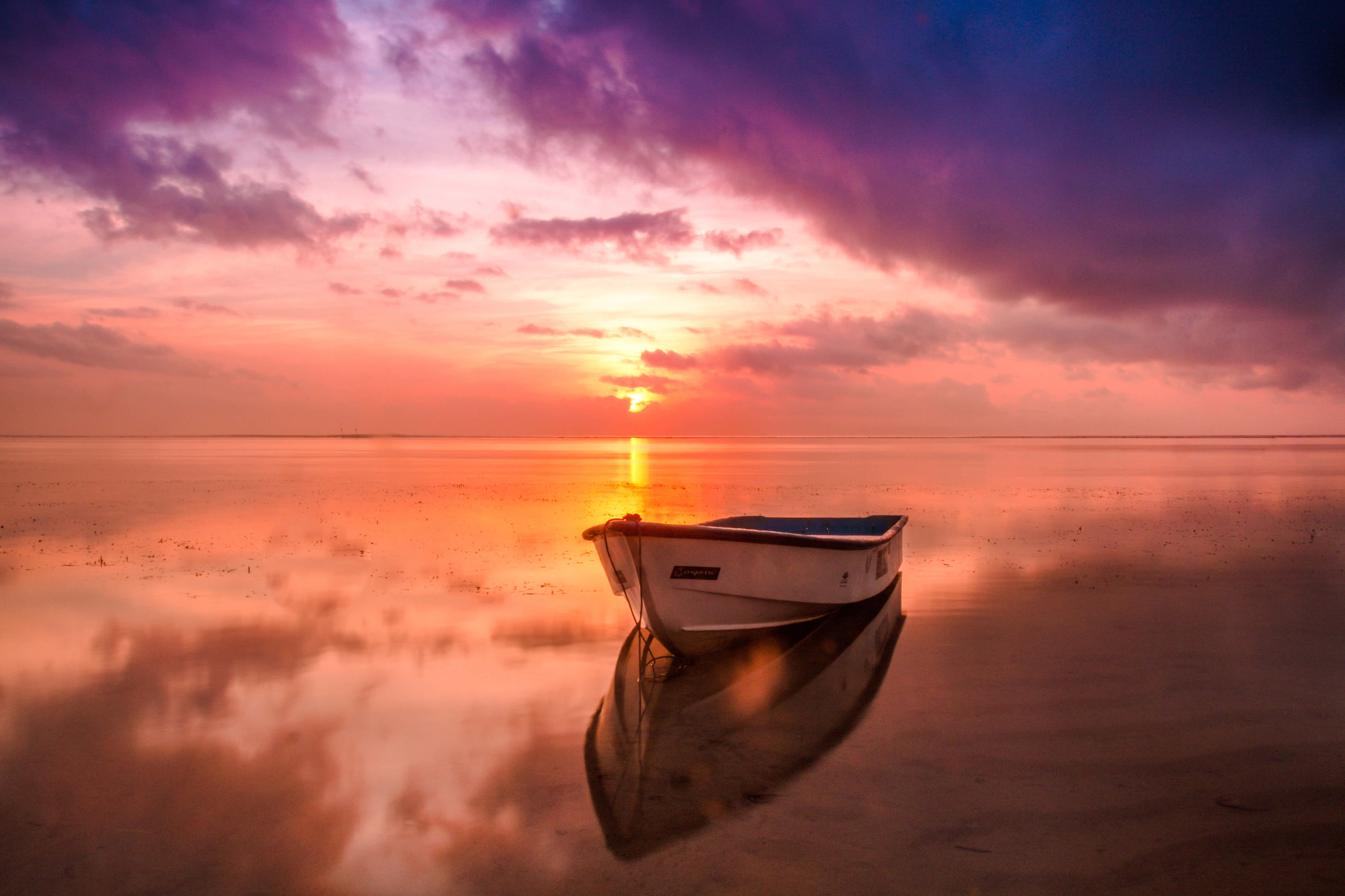 En smuk solnedgang spejler sig i en rolig sø. Wallpapers