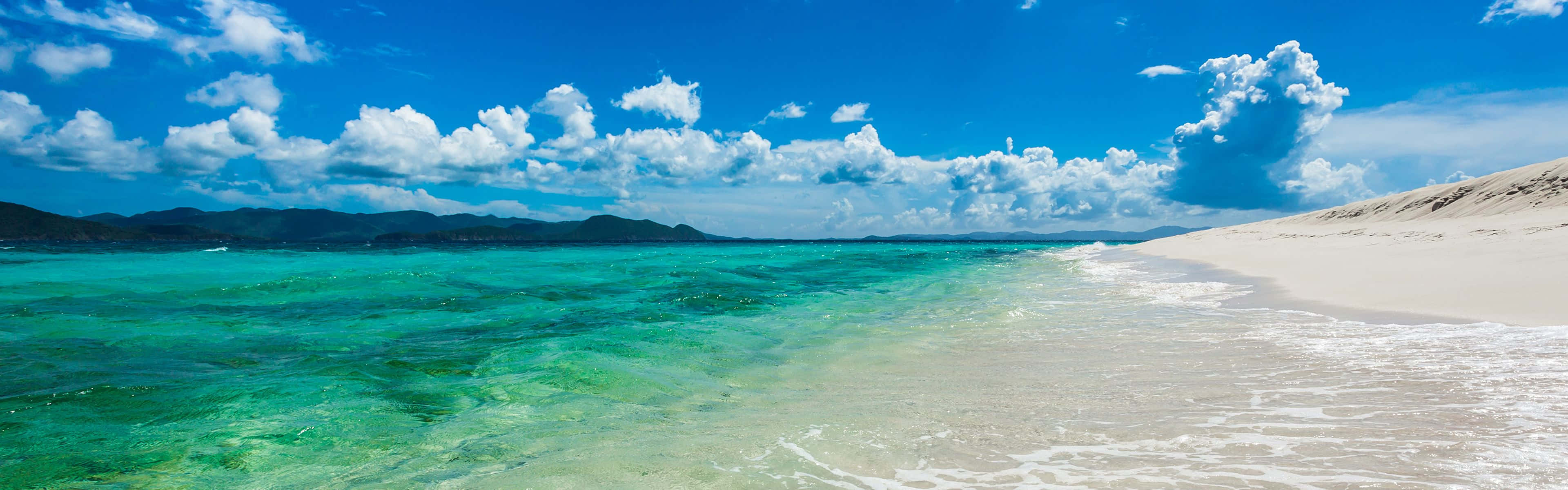 en strand med klart vand og hvidt sand Wallpapers