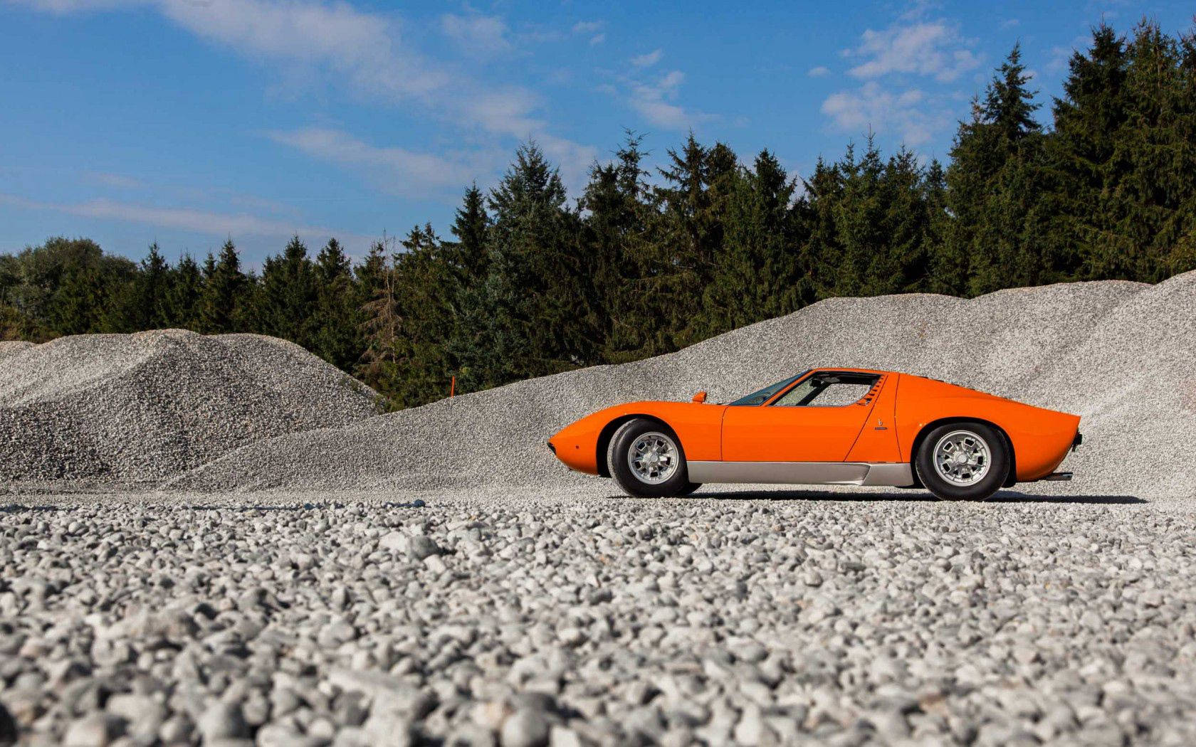 En udsøgt orange Lamborghini Miura på en grusvej. Wallpapers