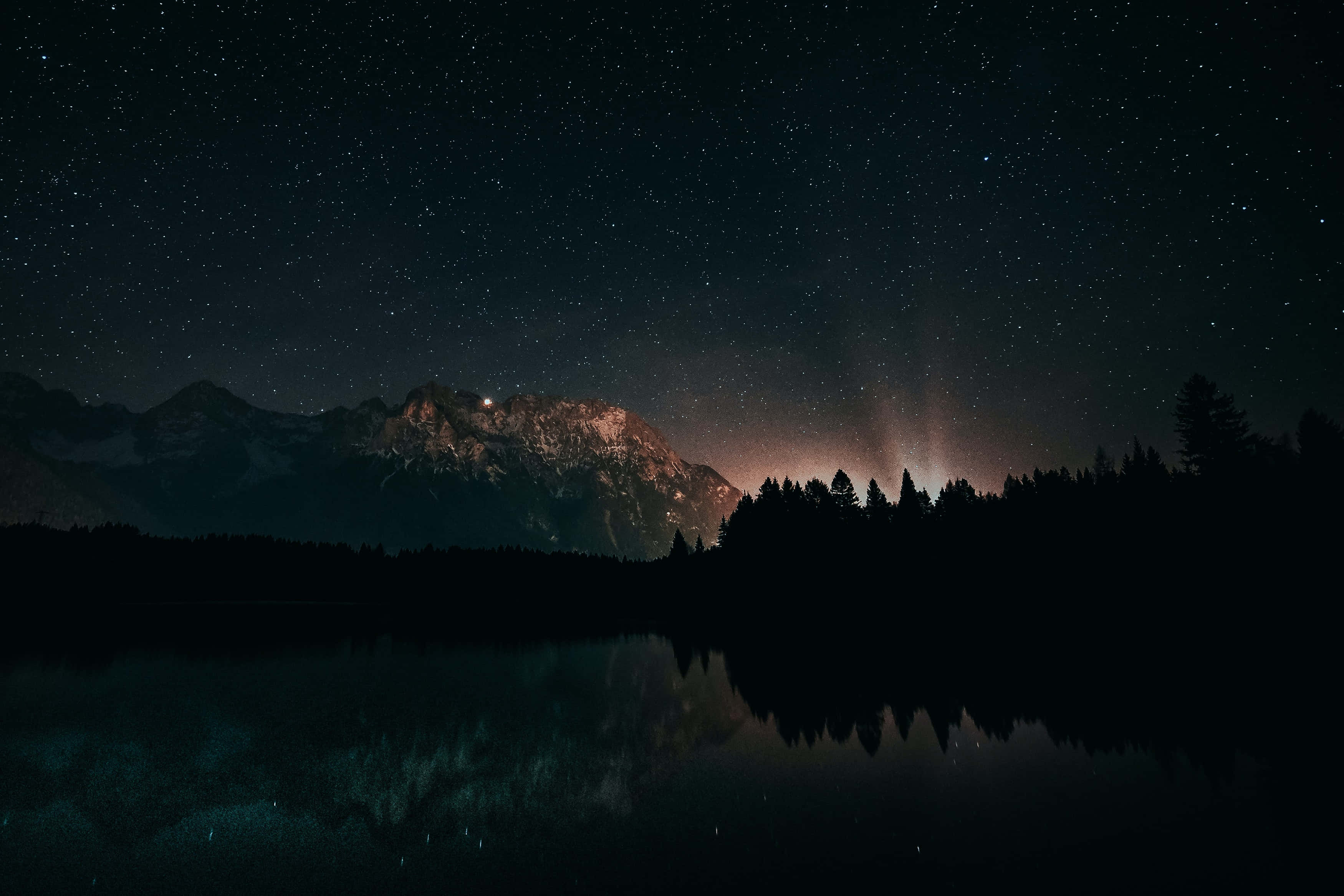 Et bjergområde med stjerner og træer om natten Wallpapers