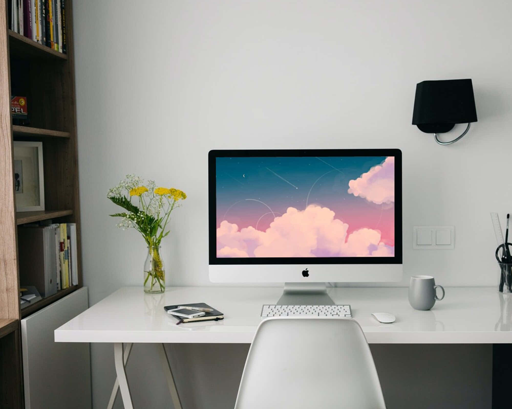 et hvidt skrivebord med en computer og en vase Wallpapers
