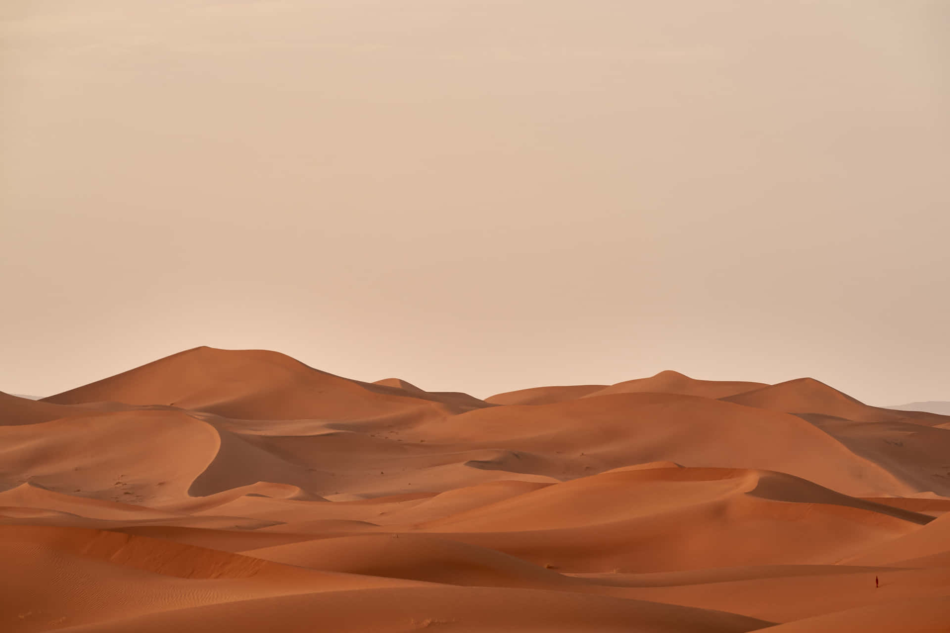 et ørkenlandskab med sandklitter og en sandstorm
