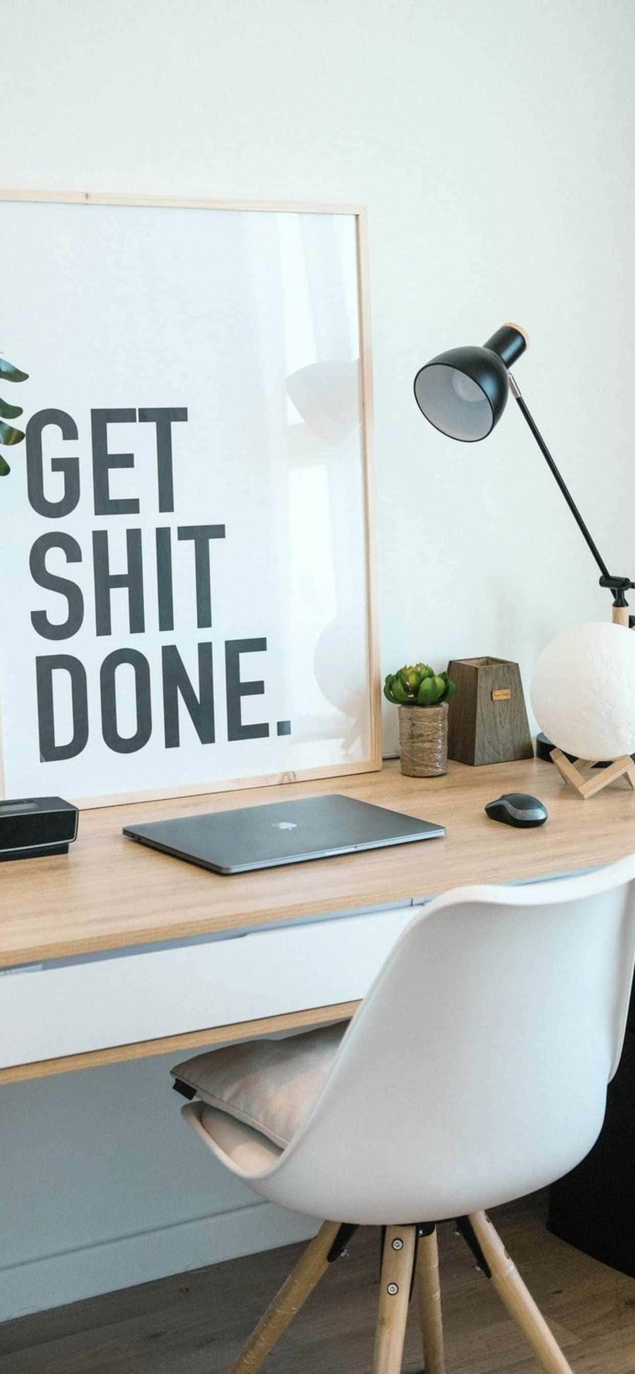 et skrivebord med en plakat, hvor der står get shit done Wallpapers