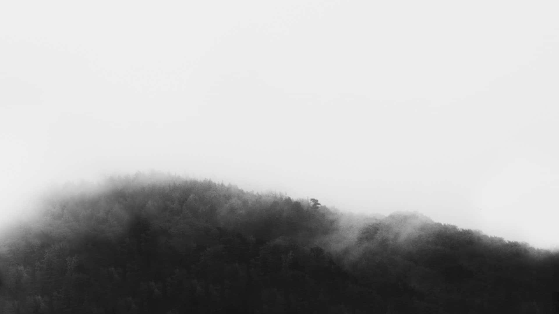 et sort/hvidt foto af et bjerg dækket af tåge Wallpapers