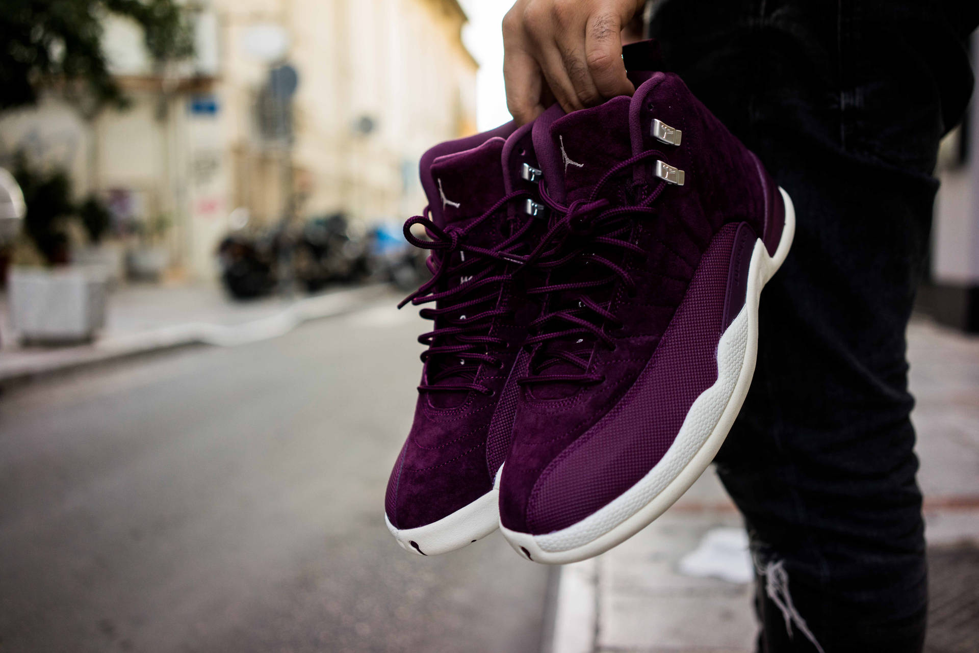 En mand, der holder et par lilla sneakers i hånden tapet. — Lilla Wallpapers