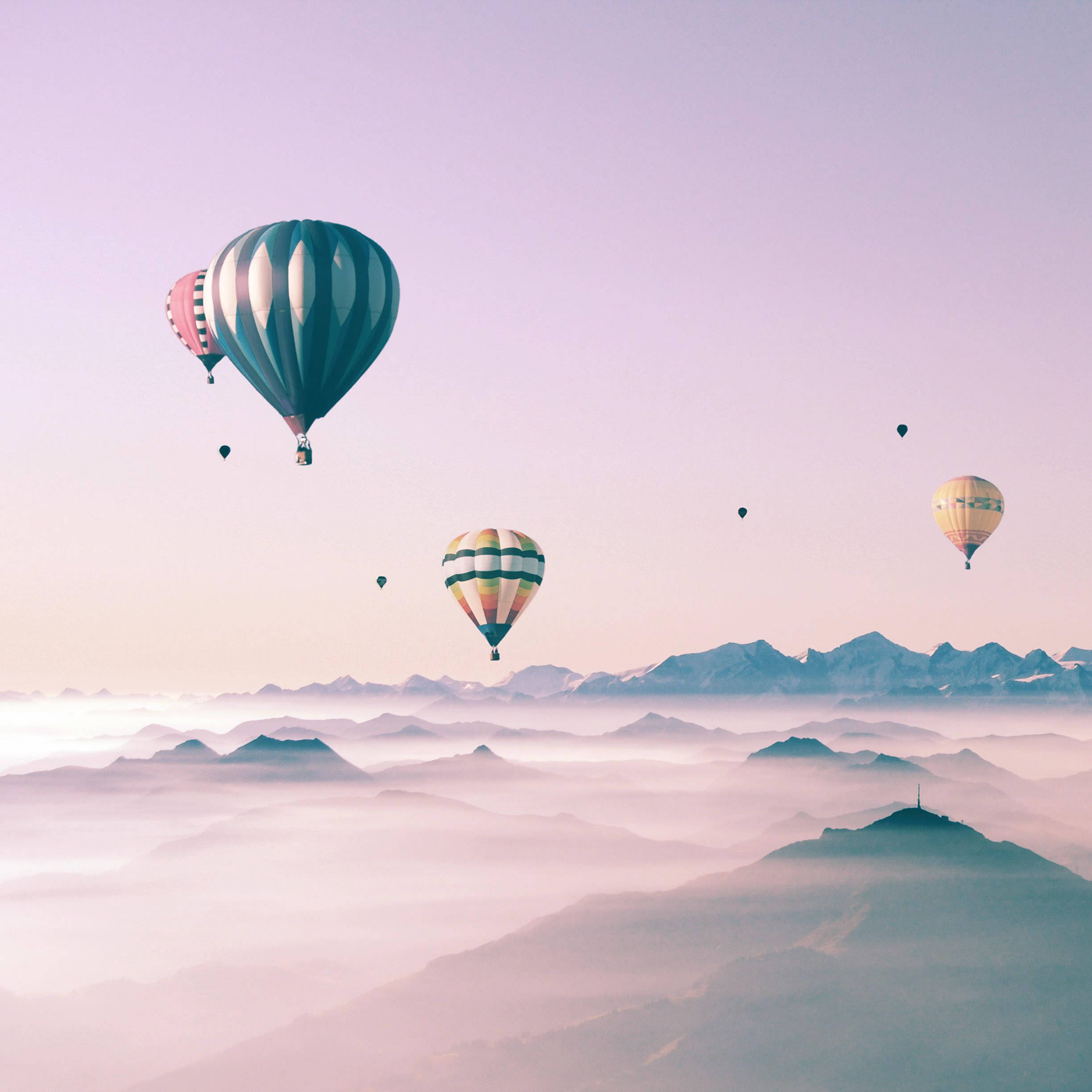 Farverige luftballoner svæver på en smuk himmel vist på en sød iPad. Wallpapers