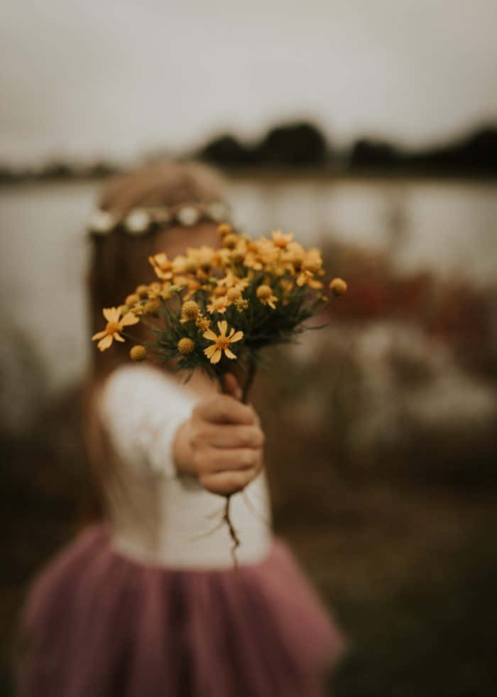 Følelsesladet pige med en gul blomst Wallpapers