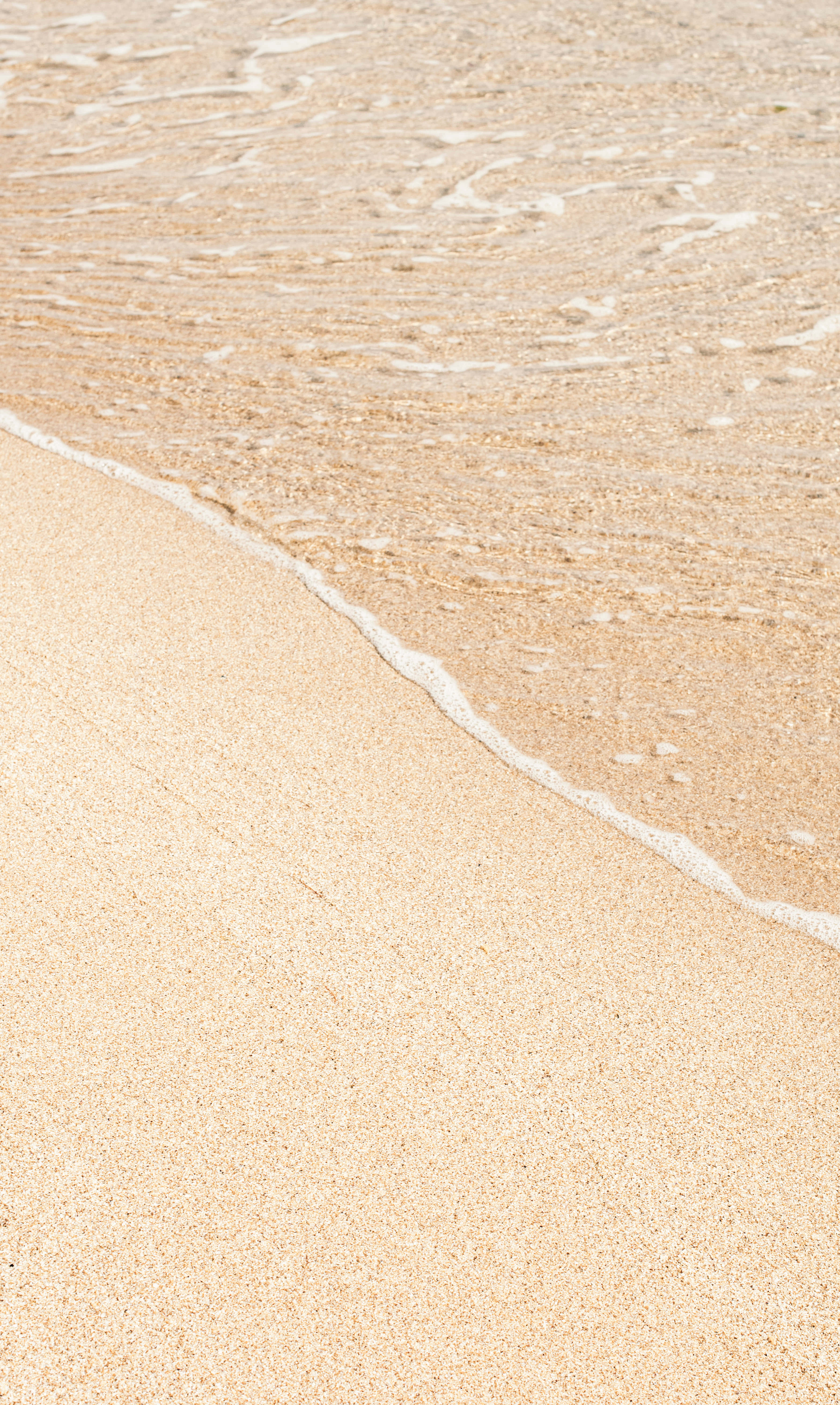 Havbølger rammer sandet på stranden Wallpapers