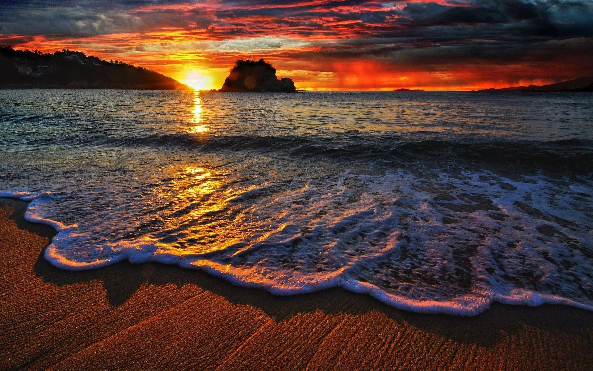 Havsolnedgang med bølger på stranden Wallpapers
