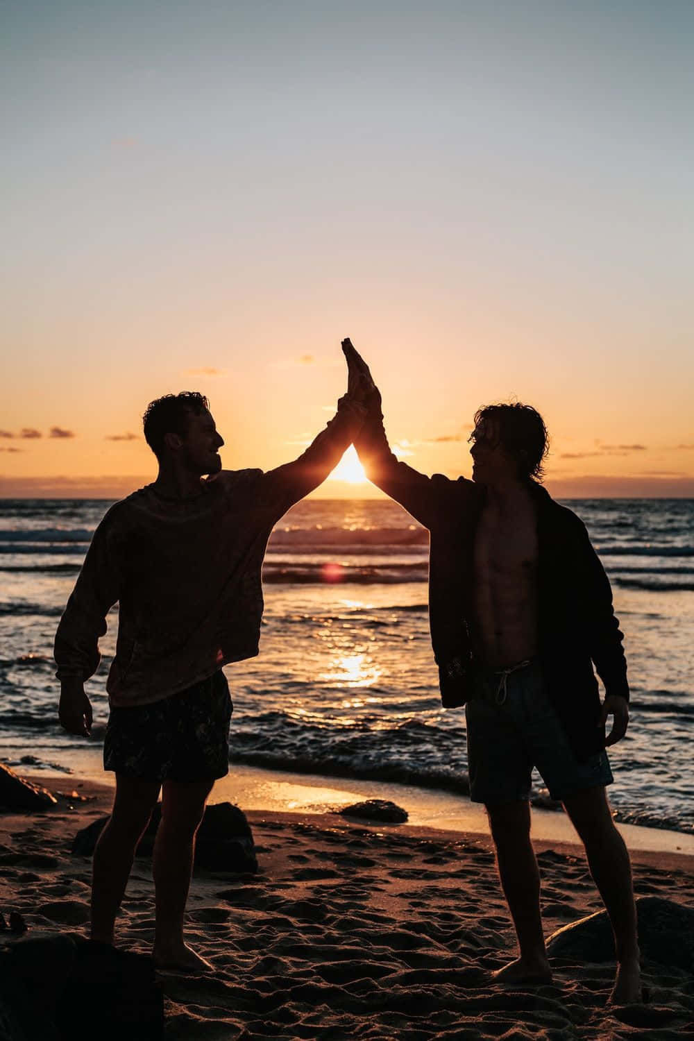 High Five ved solnedgang på stranden Wallpapers