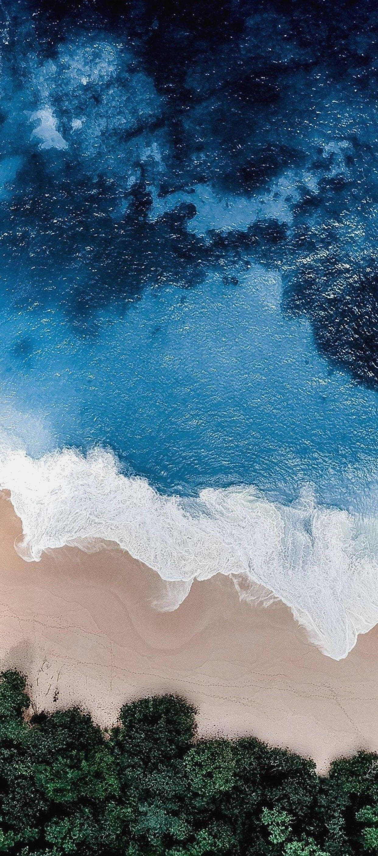 iPhone 11 svæver over havkysten Wallpapers