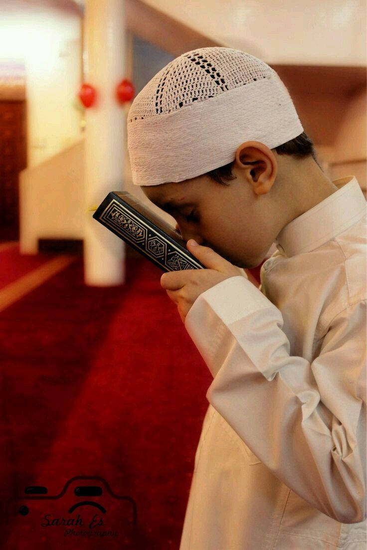 Islamisk dreng kysser Koranen Wallpapers