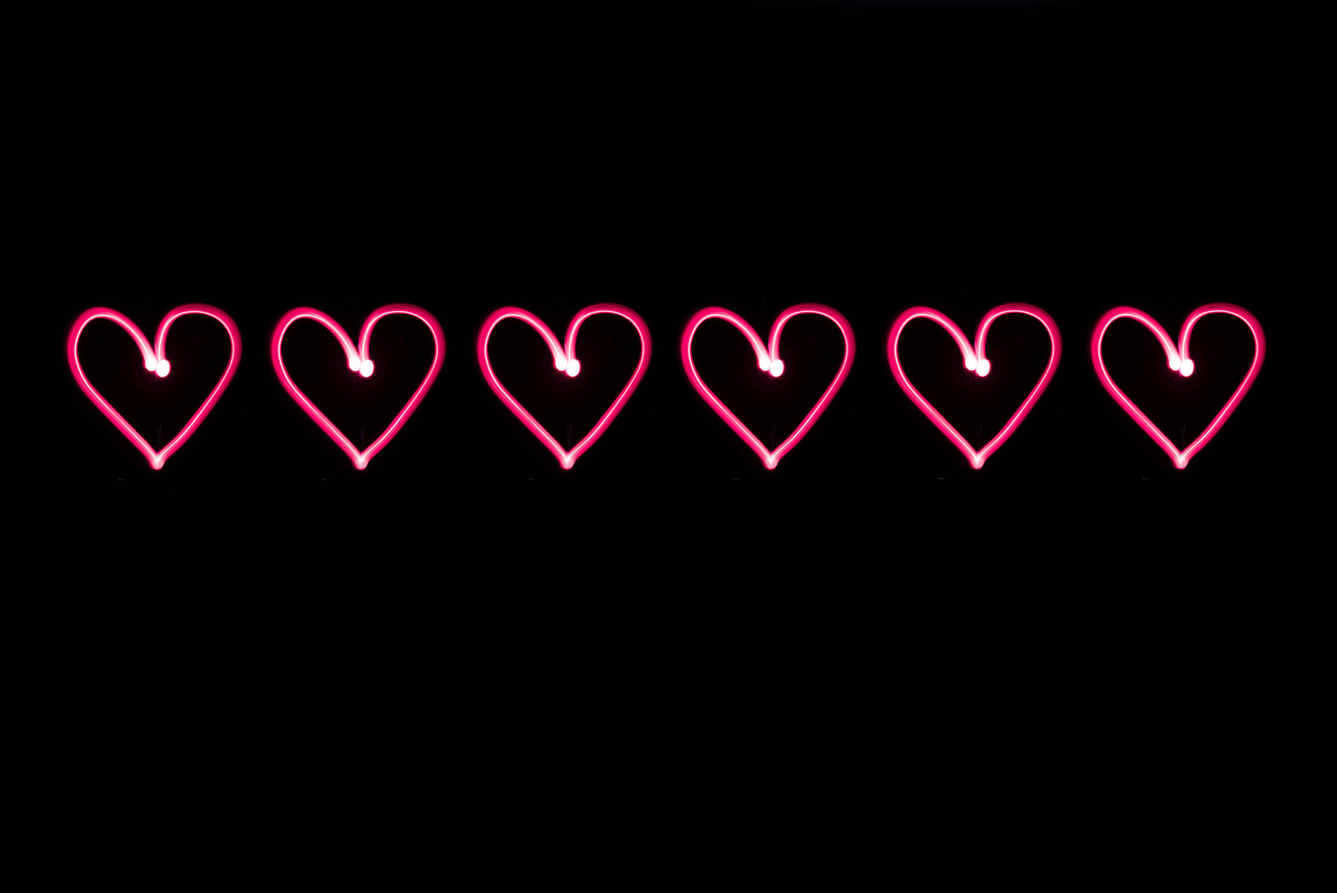 Lyserøde neonhjerter tegnet på en sort baggrund til Valentinsdag. Digital kunst til din kærlighed. — Kærlighed Wallpapers