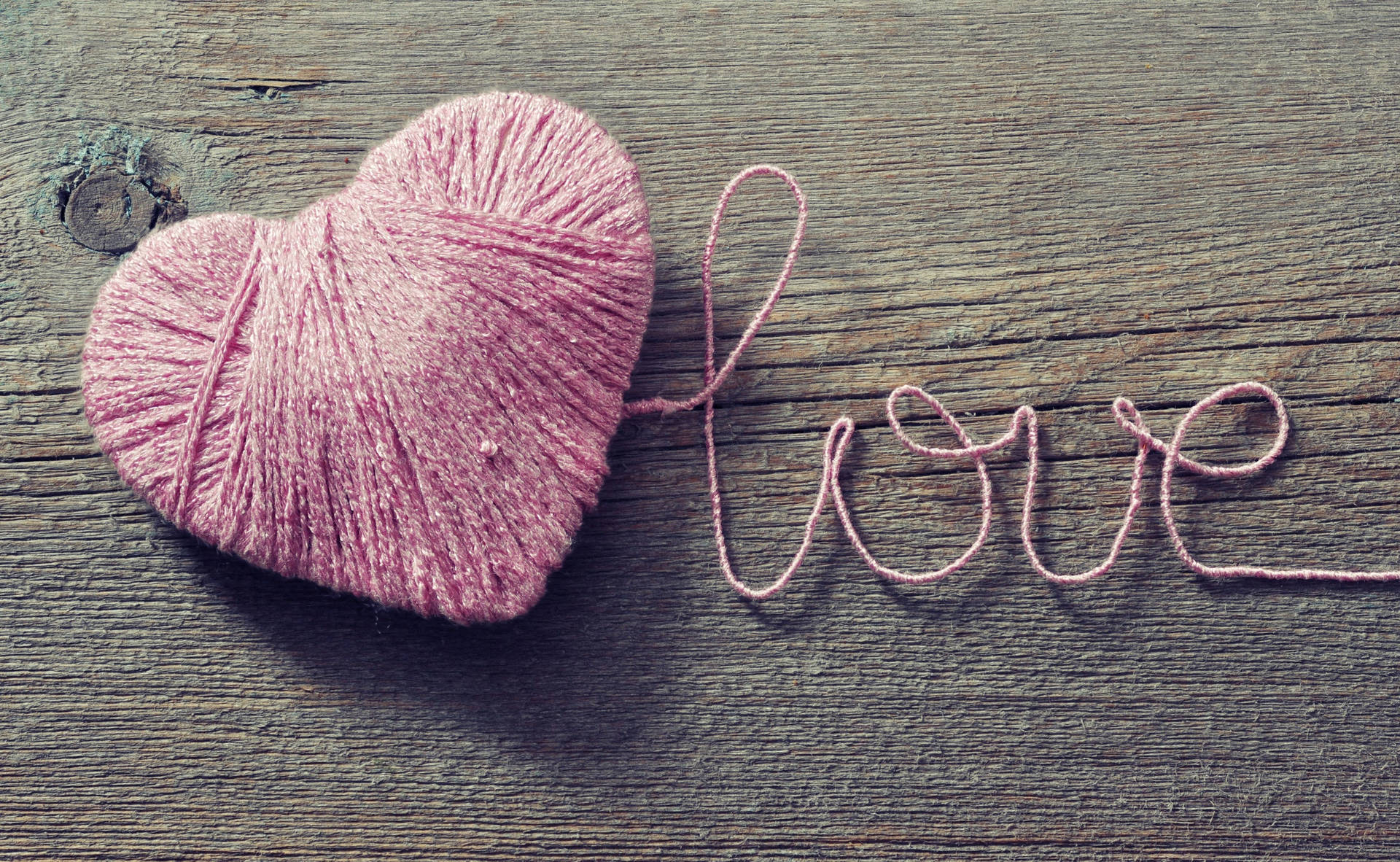 Romantisk ord "Love" skrevet med lyserød snor, der danner et hjerte på træbord til Valentinsdag. — Kærlighed Wallpapers