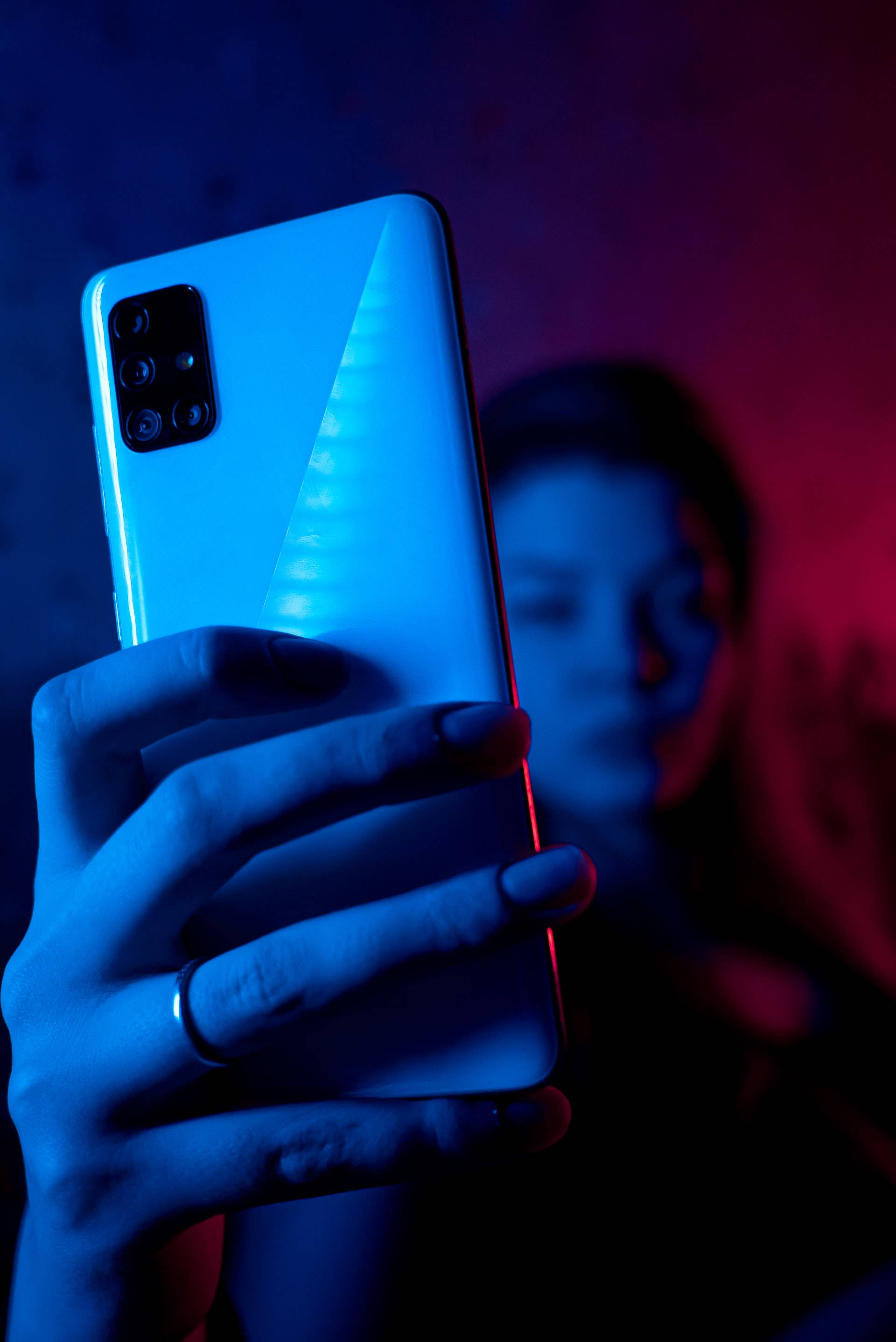 Kvinde med telefon i neonblå iPhone Wallpapers