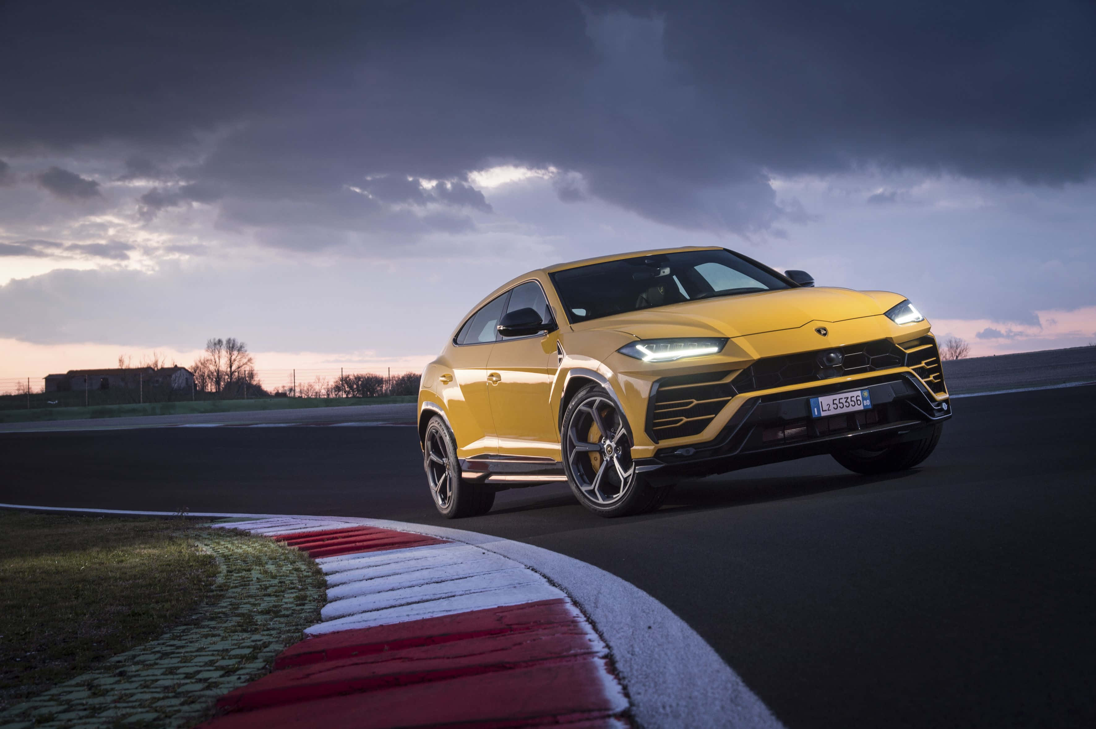 Lamborghini Urus - en gul SUV på en racerbane Wallpapers