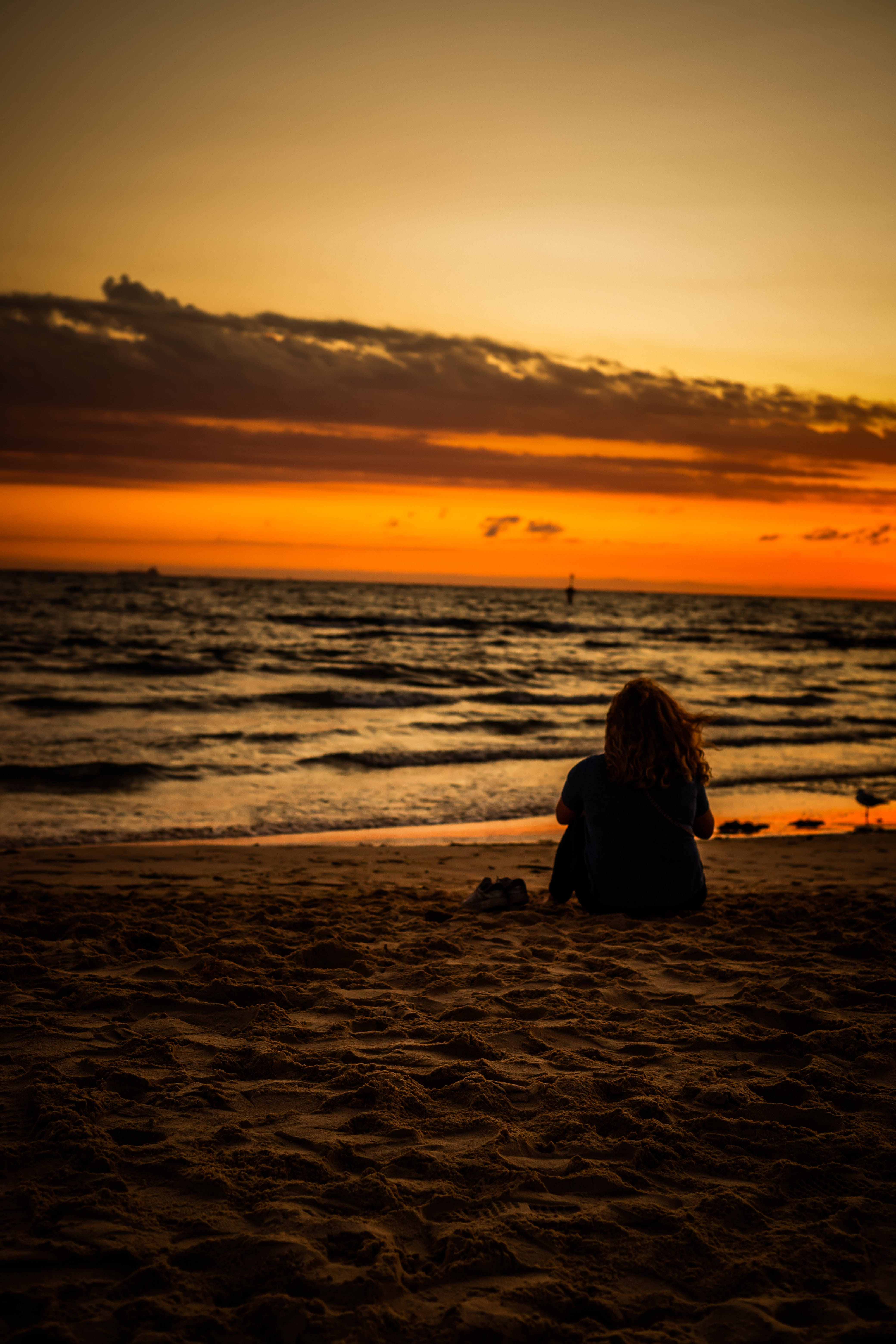 Lykkelig kvinde nyder en sommerdag på stranden Wallpapers