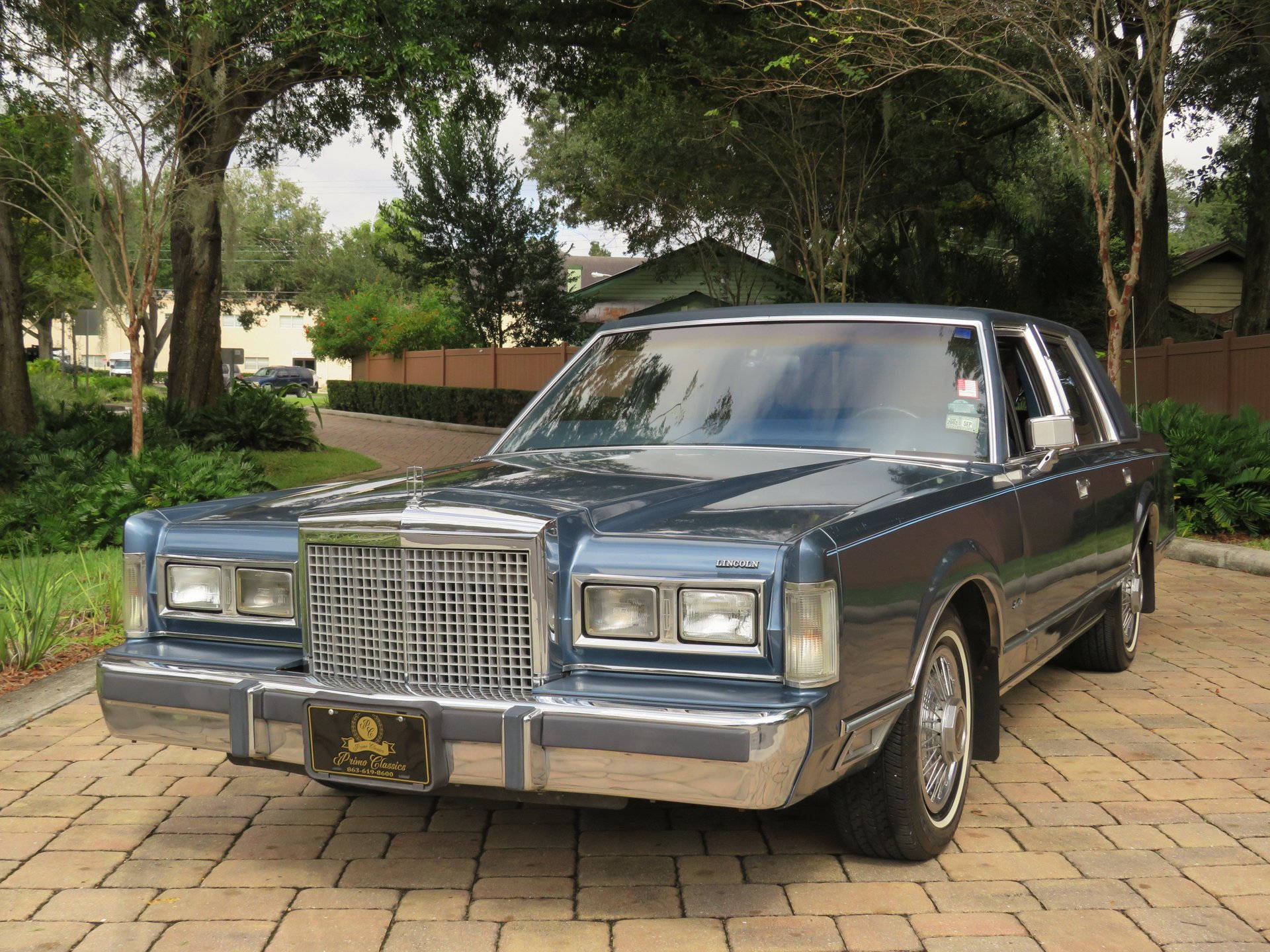 Majestætisk 1986 Lincoln Town Car parkeret på en asfalteret indkørsel Wallpapers