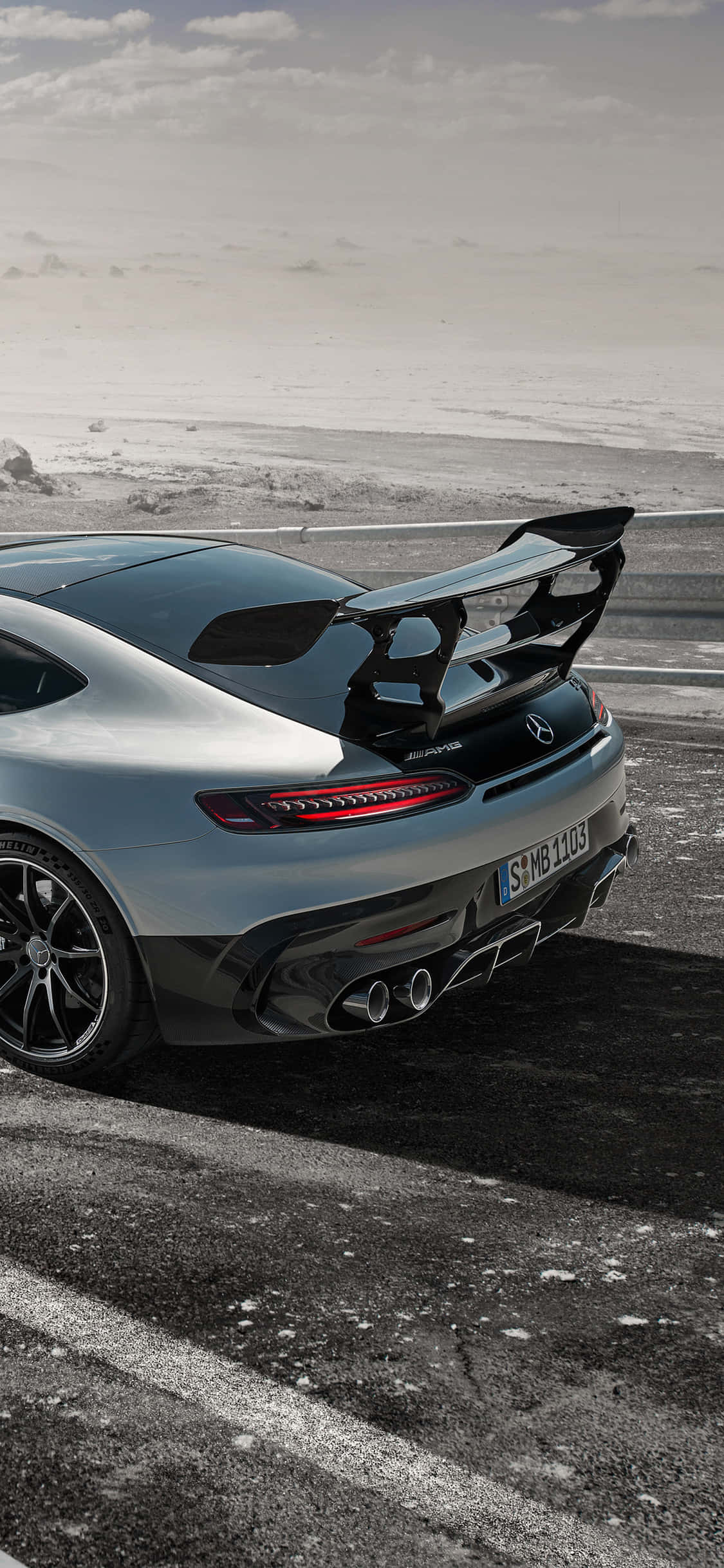 Majestætisk udsigt over en Mercedes AMG mod en malerisk baggrund gennem iPhone XS Wallpapers