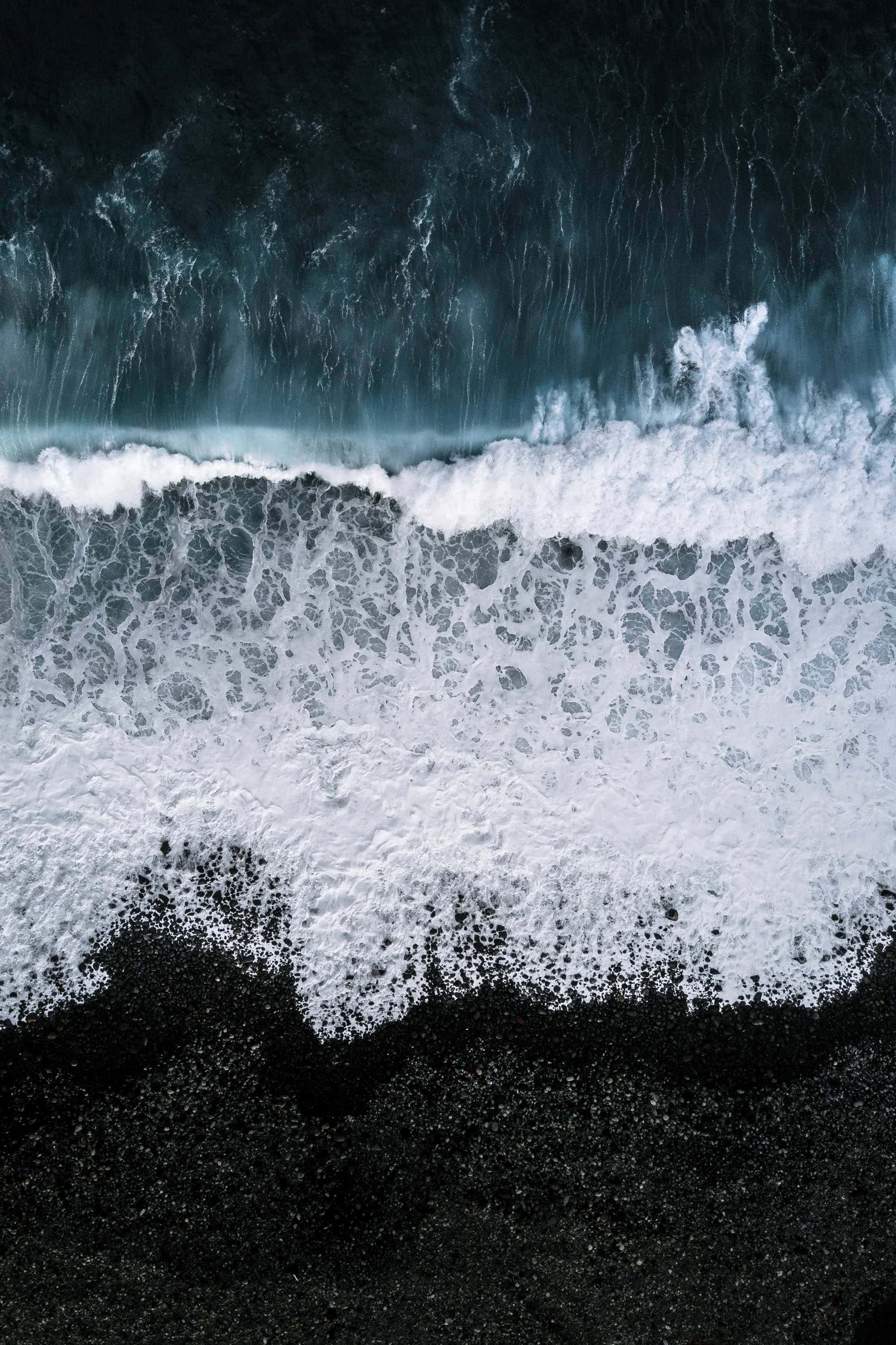 Mærk solens varme på smuk sort sandstrand. Wallpapers