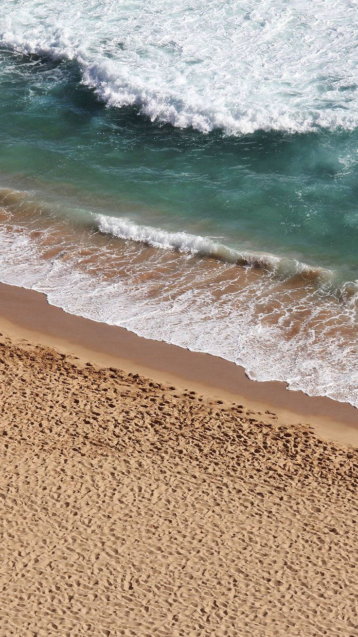 Nyd roen fra havet, der bryder mod stranden Wallpapers