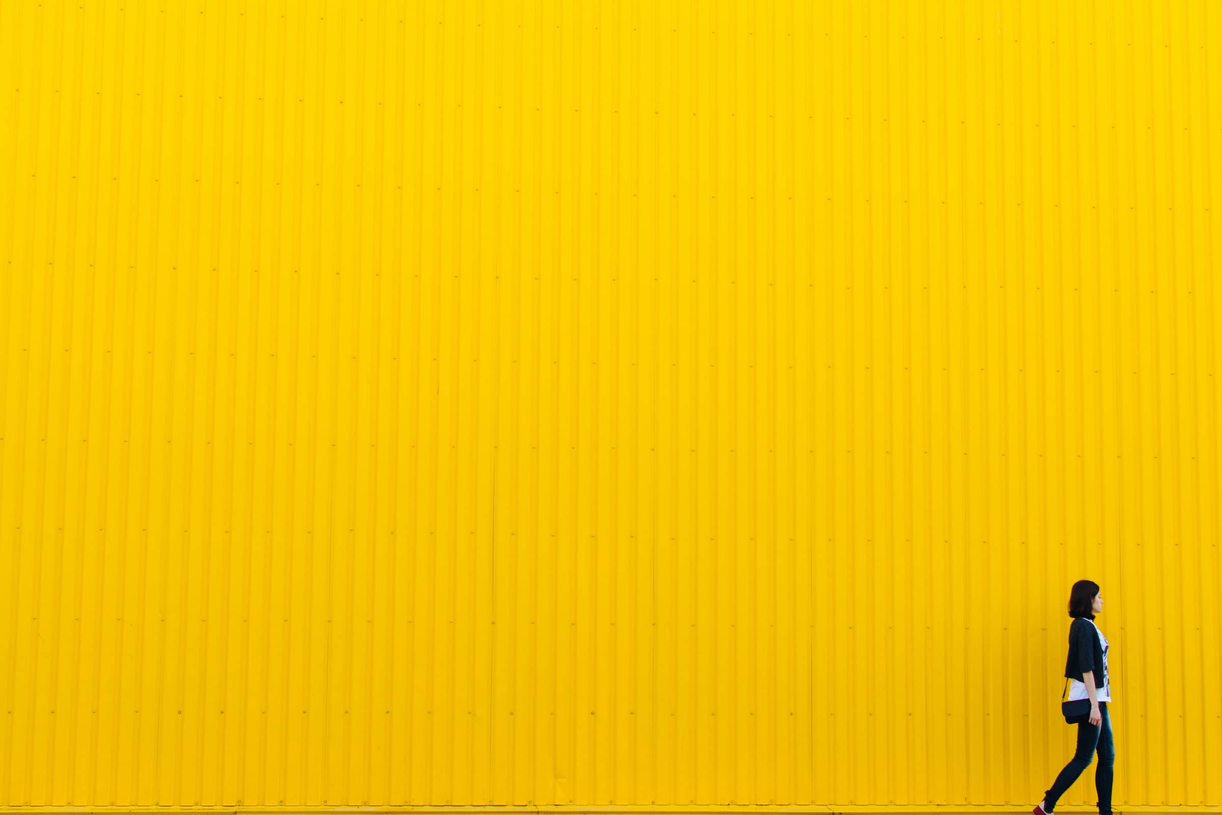 Omfavn modet - Pige mod gul væg Wallpapers