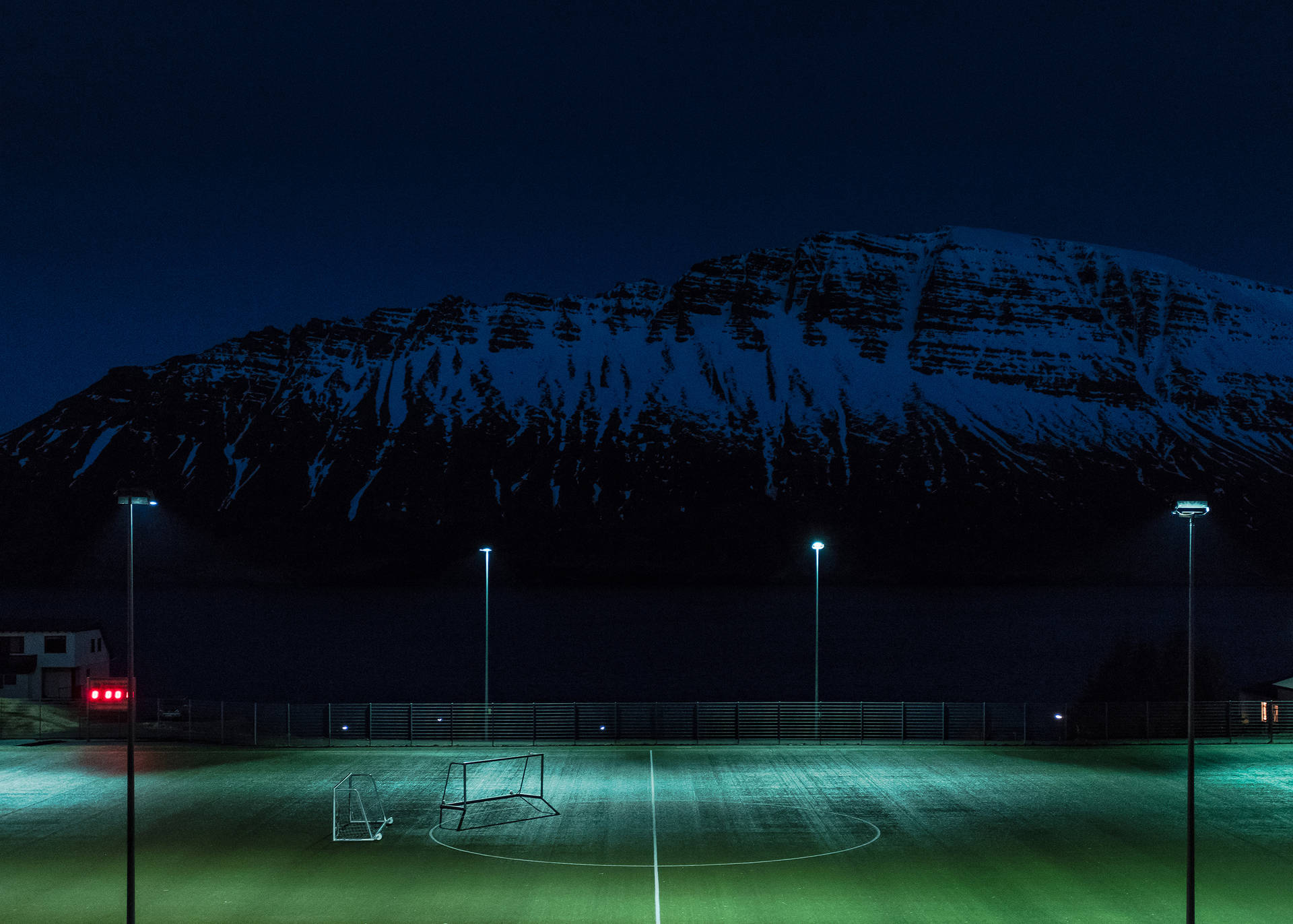 Natfodboldbane oplyst af lysmaster baggrund. — Fodbold Wallpapers