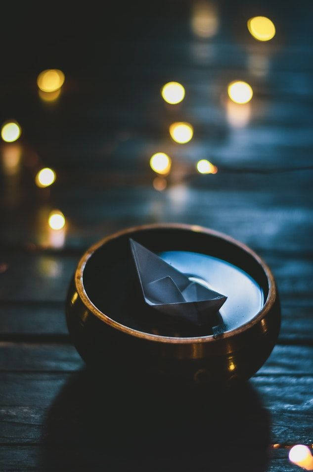 Origami-båd flyder i skål Wallpapers