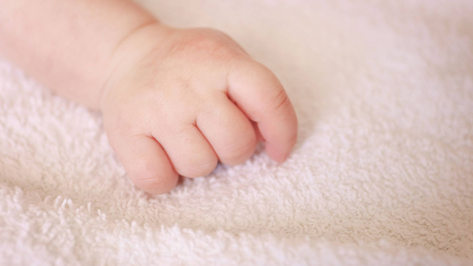 Sart lille babyhånd hvilende på blødt håndklæde Wallpapers